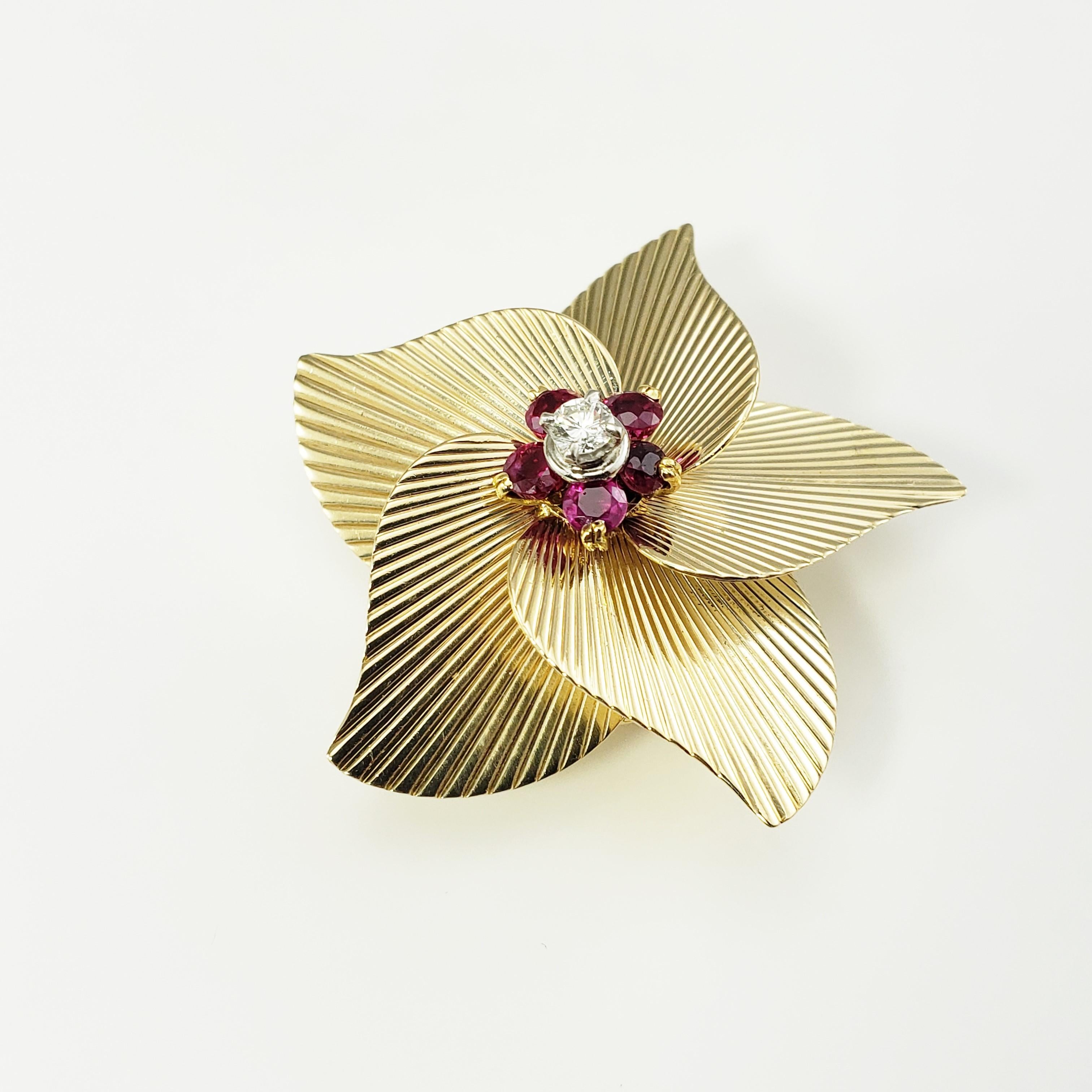 Tiffany & Co. 14 Karat Yellow Gold Ruby and Diamond Brooch/Pin-

This lovely Tiffany flower brooch is accented with one round brilliant cut diamond and five rubies set in beautifully detailed 14K yellow gold.

Total diamond weight:  .15 ct.

Diamond