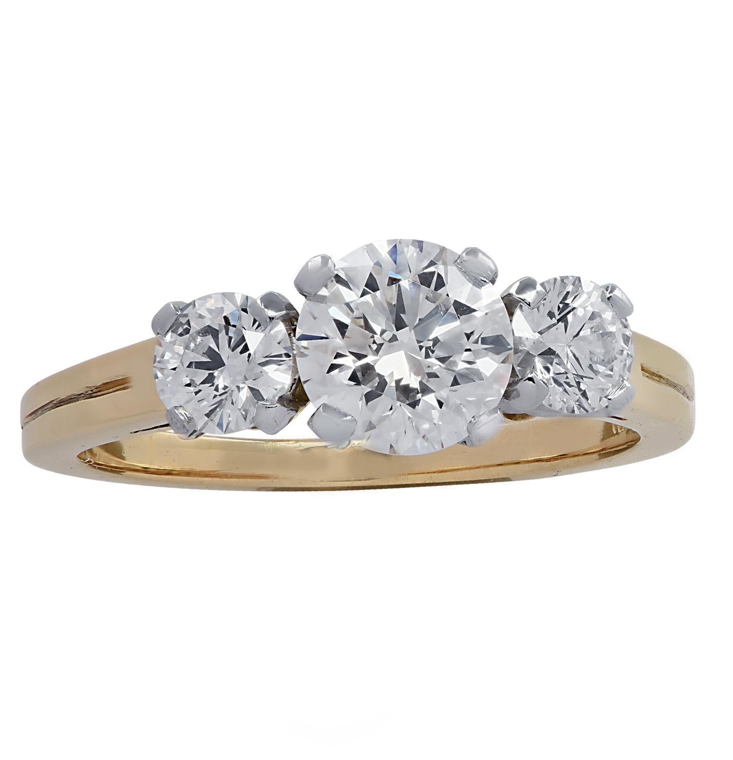 Tiffany & Co. Three Stone Engagement Ring crafted in 18 karat yellow gold and platinum, showcasing a round brilliant cut diamond weighing .90 carats, H-I color VS clarity accented by 2 round brilliant cut diamonds weighing approximately .50cts total