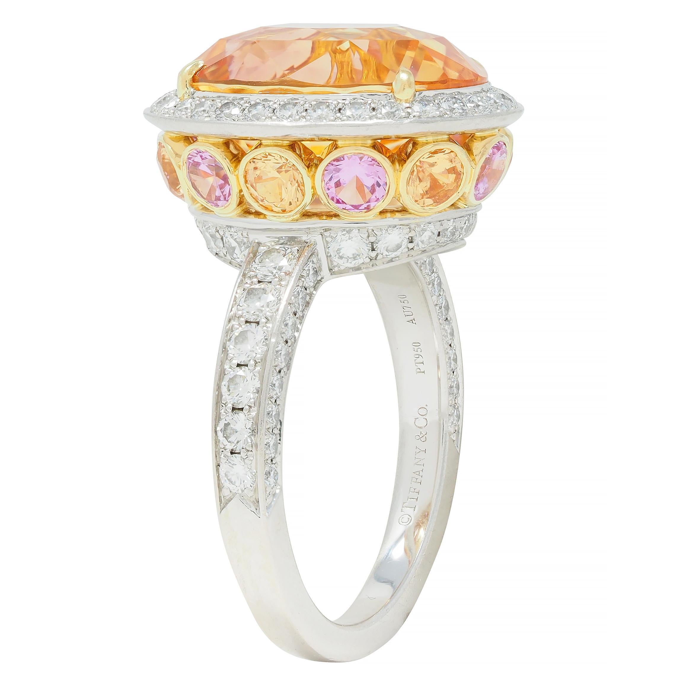 Centering an oval mixed-cut sapphire weighing 11.10 carats - transparent golden orange-yellow
Natural Ceylon (Sri Lankan) in origin and displaying no indications of heat treatment 
Set by yellow gold prongs with a halo surround of round brilliant