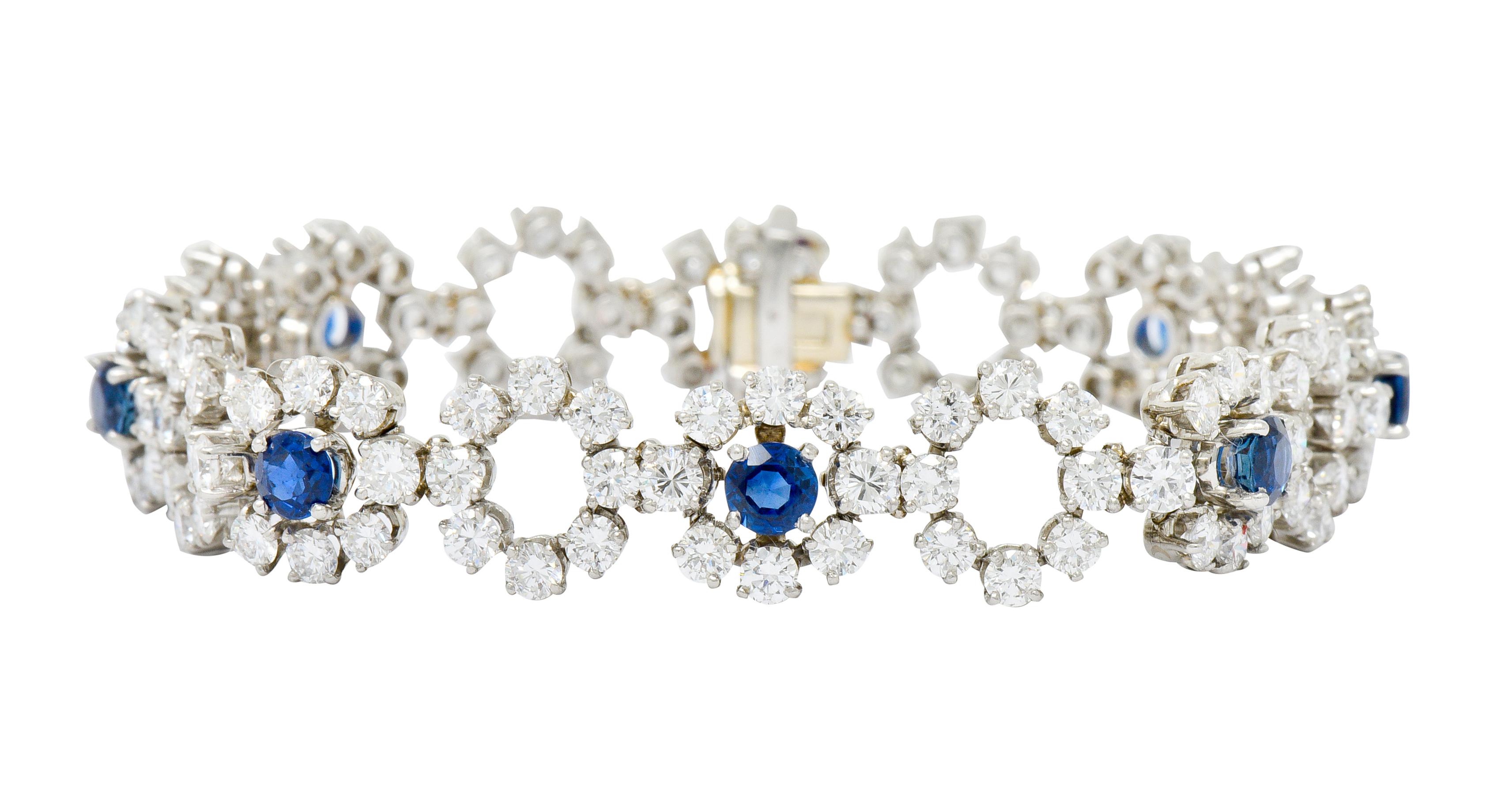 Link style bracelet comprised of floral diamond clusters with some that center round cut sapphire

Round brilliant cut diamonds are F/G in color with VVS clarity and weigh approximately 10.56 carats in total

Eight sapphire are a very well-matched