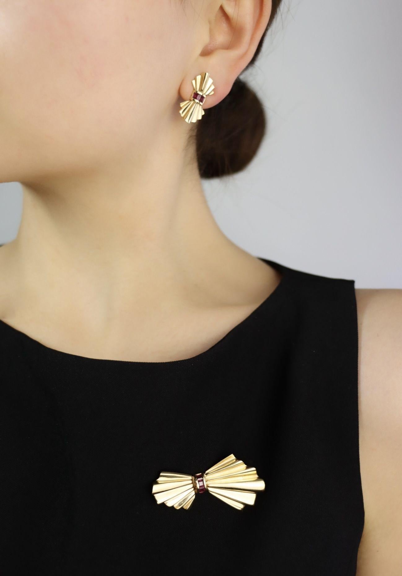 Tiffany & Co. 14K Gold Ruby Bow Clip Earrings & Brooch

Marked:
TIFF & Co. 
14K

Approximate Dimensions:

Earrings
2.6 cm (Length) 
1.2 cm (Width)
Approx.0.48 carat (Ruby)
7.1 grams in weight.

Brooch
5.3 cm (Length) 
2.8 cm (Width)
Approx.0.4 carat