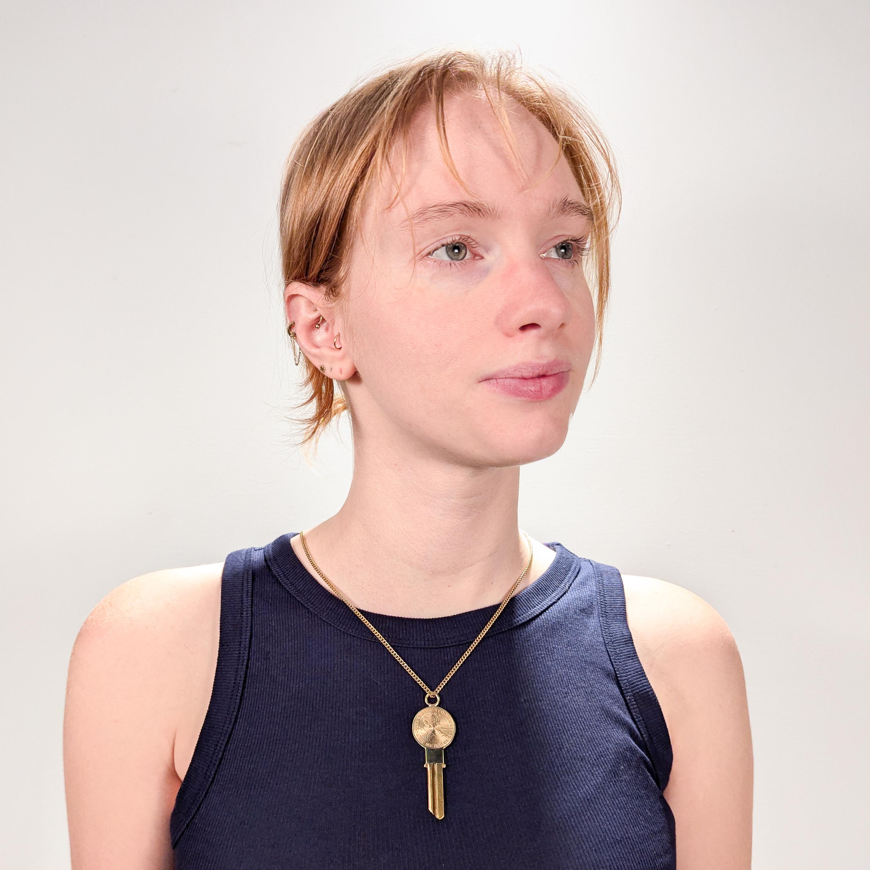 A fine estate gold key pendant.

By Tiffany & Co.

In 14 karat yellow gold.

In the form of a uncut key with a brass key and a gold top. 

Engraved with an engine turned depiction of St. Christopher carrying Christ across the river.

With an
