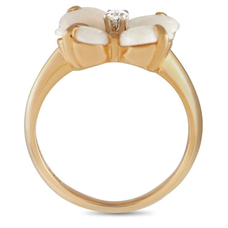 A delicate piece of jewelry to polish a chic and feminine look. This is a 14K yellow gold ring topped with a floral motif made up of four heart-shaped opal petals and a central diamond. Rounded claw prongs hold each stone while bringing extra style