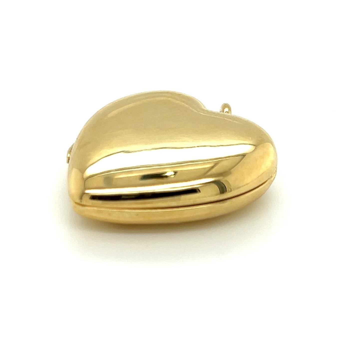 This keepsake authentic vintage locket pendant is from Tiffany & Co., crafted from 14k yellow gold with a polished finish featuring a double side frame heart shape hinged pendant. It opens to reveal a double heart shape frame with a snap shut clasp.