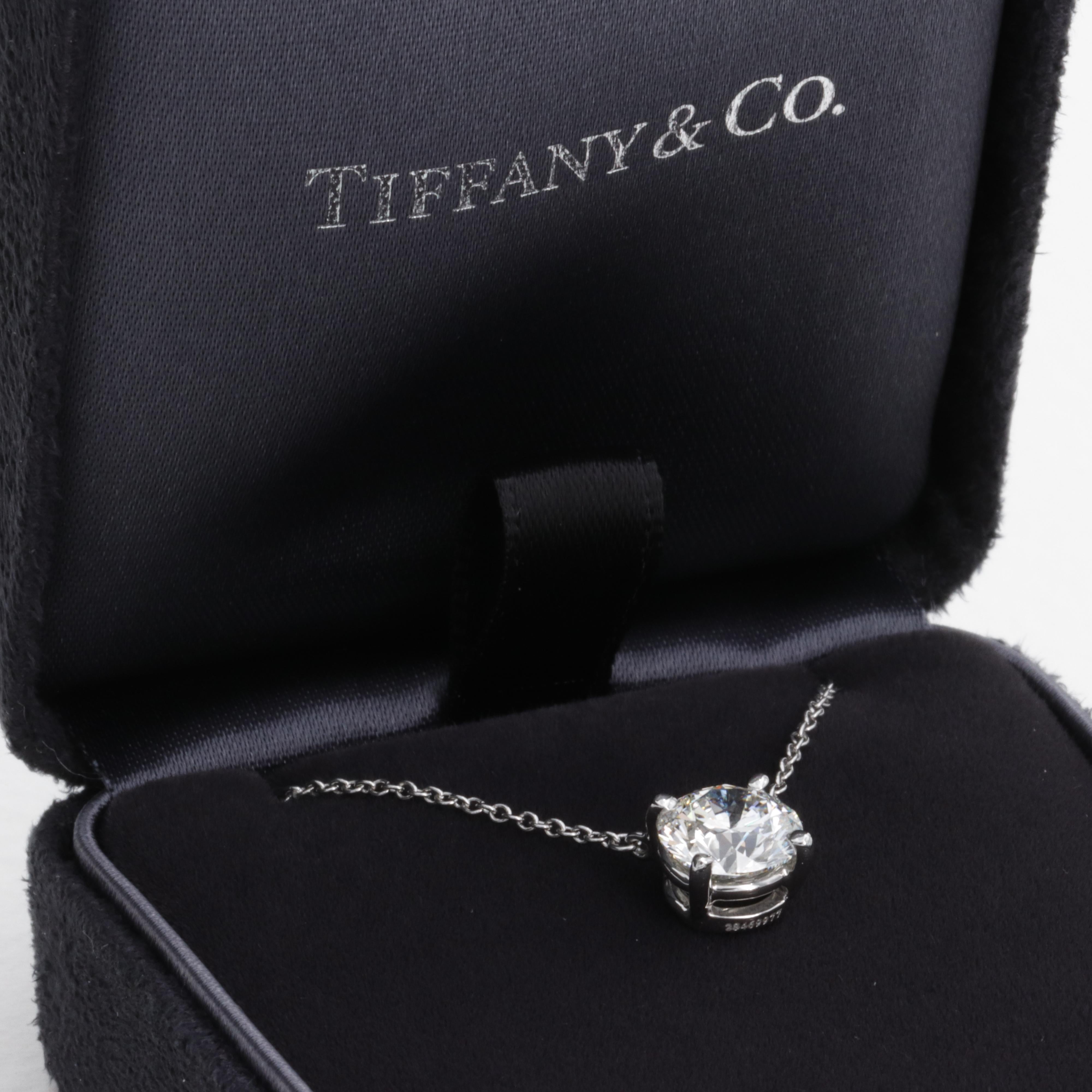 This fine natural diamond solitaire pendant necklace by Tiffany & Co. features a beautiful excellent cut 1.63 carat I color VVS2 clarity round brilliant cut diamond center stone. 

The diamond is expertly set in it's original Tiffany & Co. platinum
