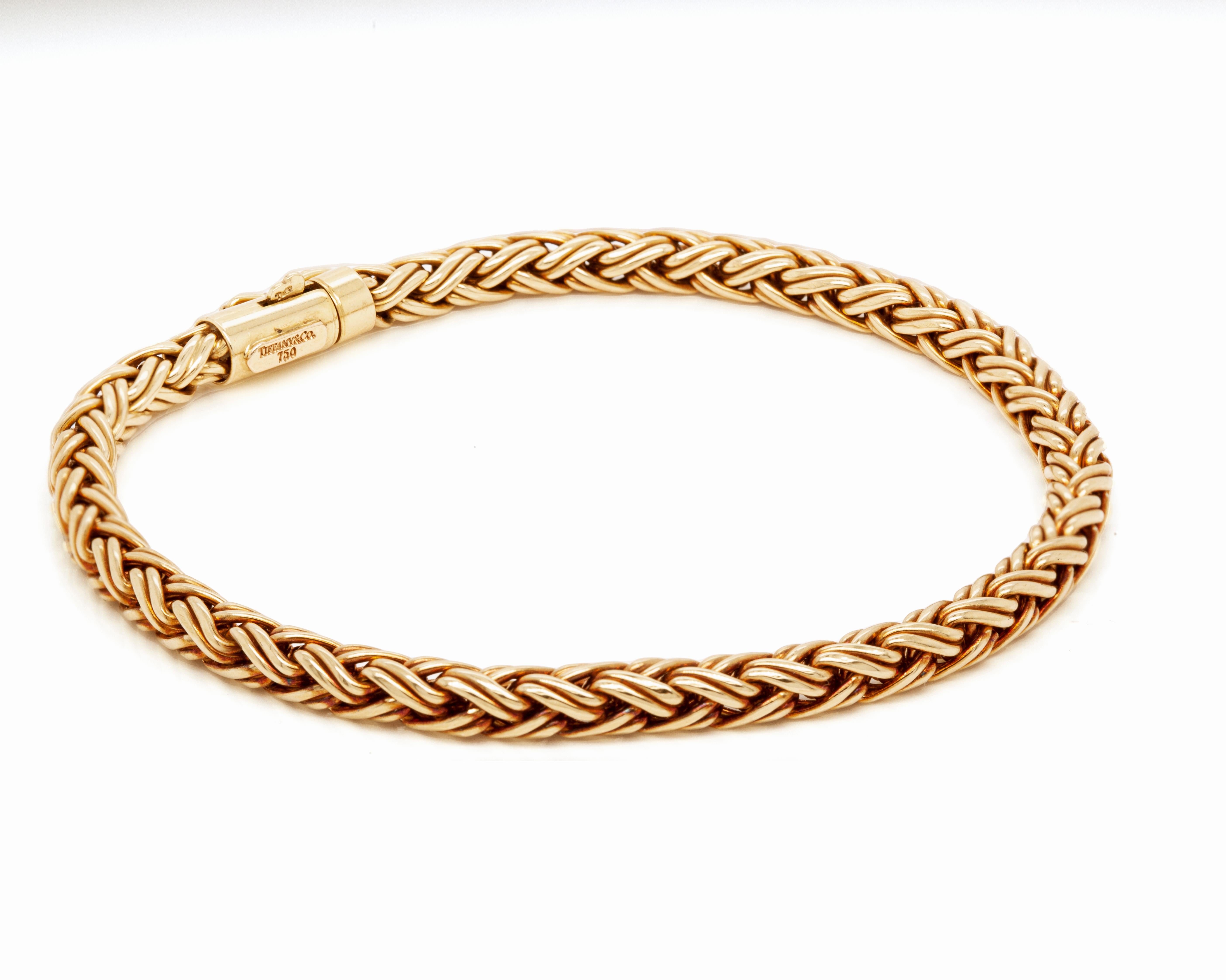 A classic and beautiful chain necklace and bracelet set by Tiffany & Co. masterfully crafted from 18 carat yellow gold.

Both necklace and bracelet feature a braided round wheat chain design and are perfectly secured with a tube box clasp. Measuring