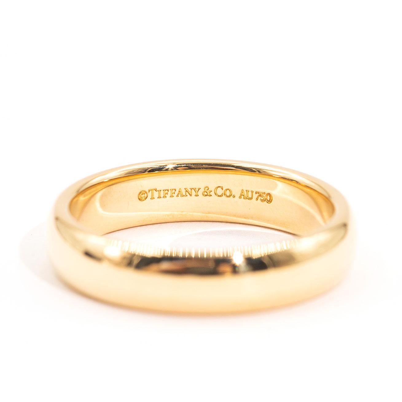 Crafted in 18 carat yellow gold is this vintage Tiffany & Co Tiffany Classic Wedding Band Ring. The Tiffany & Co Tiffany Classic Wedding Band Ring measures 4.5 millimetres and 1.85 millimetres in thickness. The Tiffany & Co Tiffany Classic Wedding