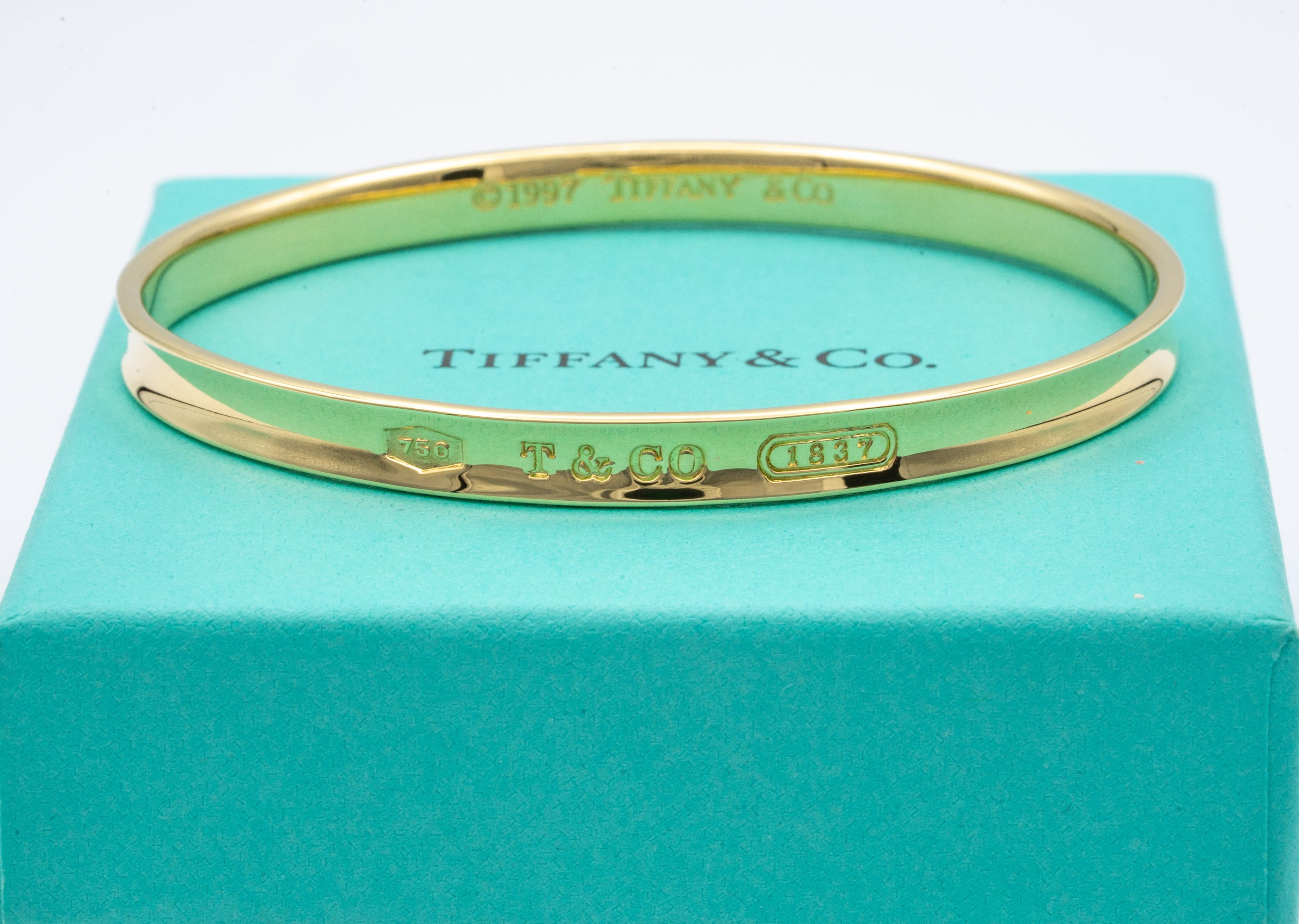 Tiffany & Co. slip on bangle bracelet finely crafted in 18 karat yellow gold. Pertaining to the Tiffany & Co. 