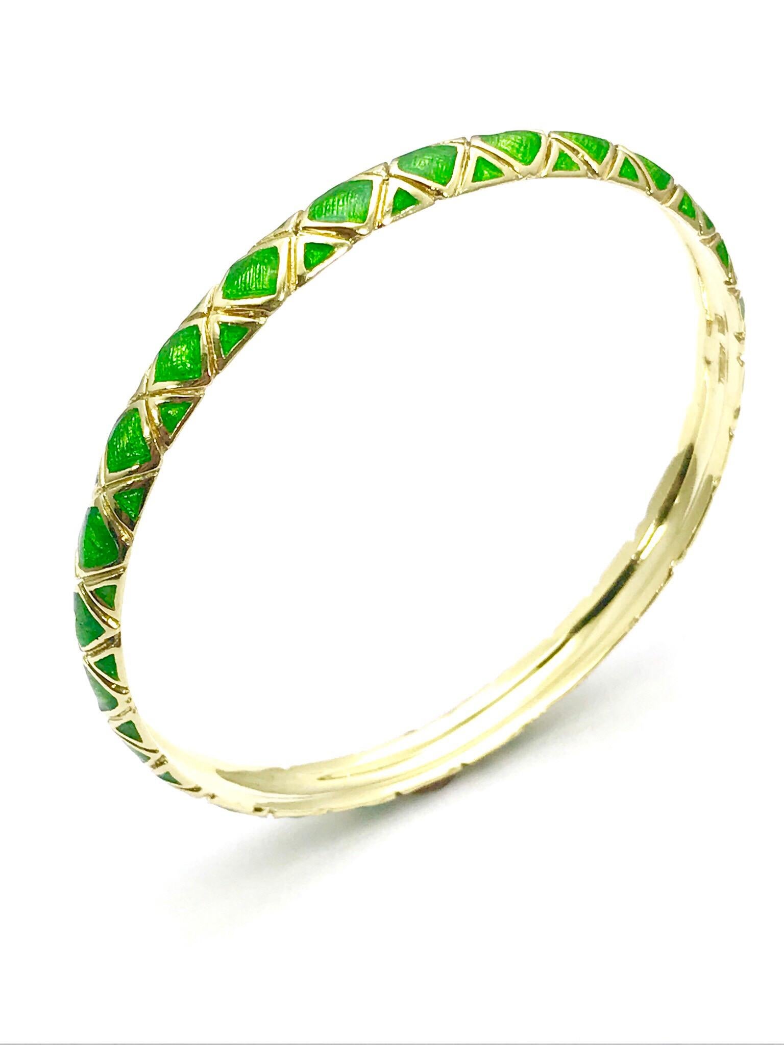 A beautiful Tiffany & Co. 18 karat yellow gold bangle bracelet finished in a vibrant emerald green guilloche enamel.  The bracelet shows an 