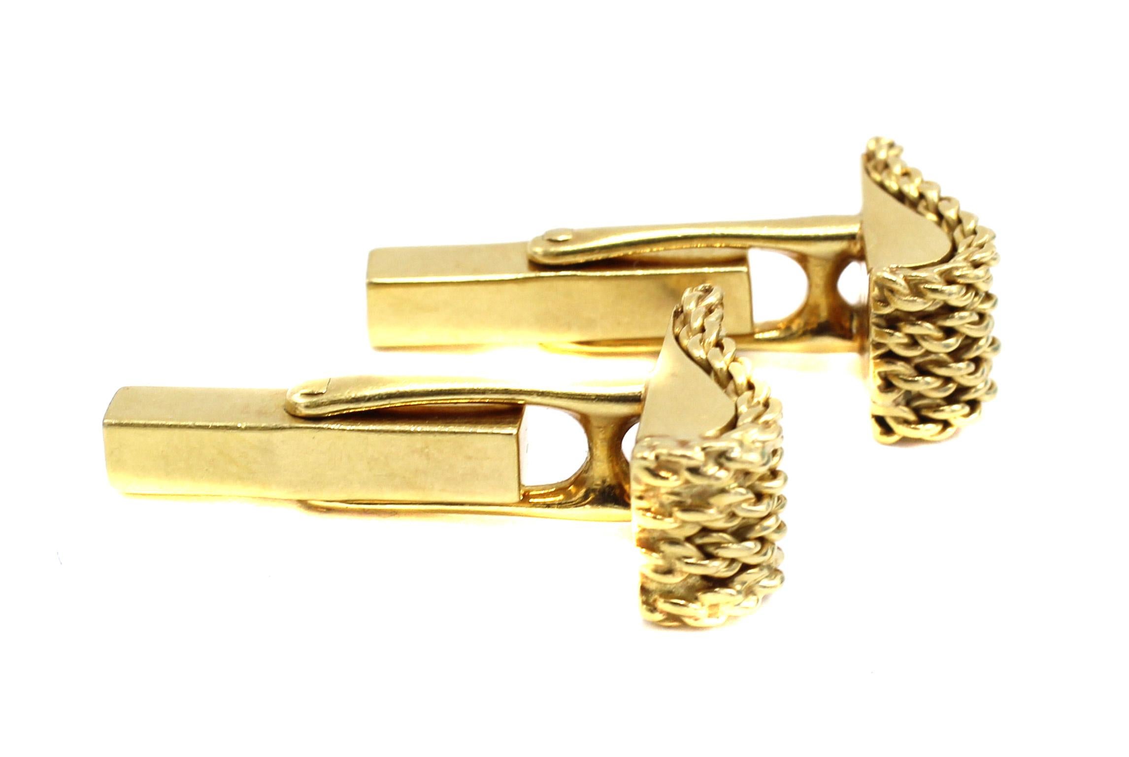 1980s cuff-links by Tiffany & Company designed in the shape of a wave with bars of finely braided gold worked on the top. Secured by a gold swivel-bar on the back, easy to fit into any shirt, masterfully hand-crafted in 18 karat yellow gold. Signed
