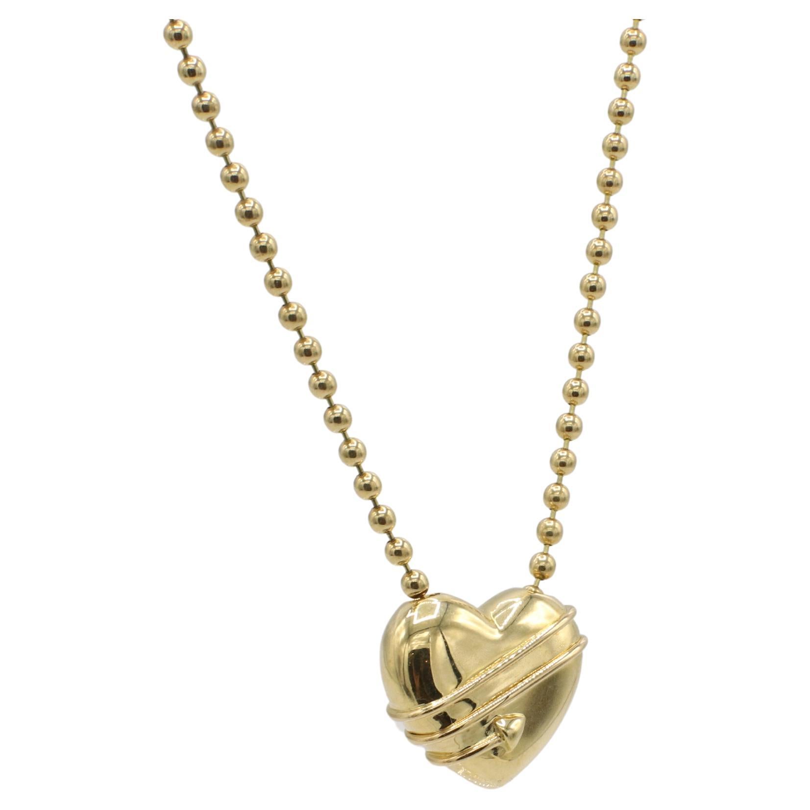 Tiffany 
Co. 18 Karat Gold Puffed Heart Cupid Arrow Bead Chain Necklace 1994
Metal: 18k yellow gold
Weight: 22.16 grams
Heart: 18 x 20.5mm
Chain: 17 inches
Signed: ©1994 Tiffany 
Co. 18K
RRSI F35001597