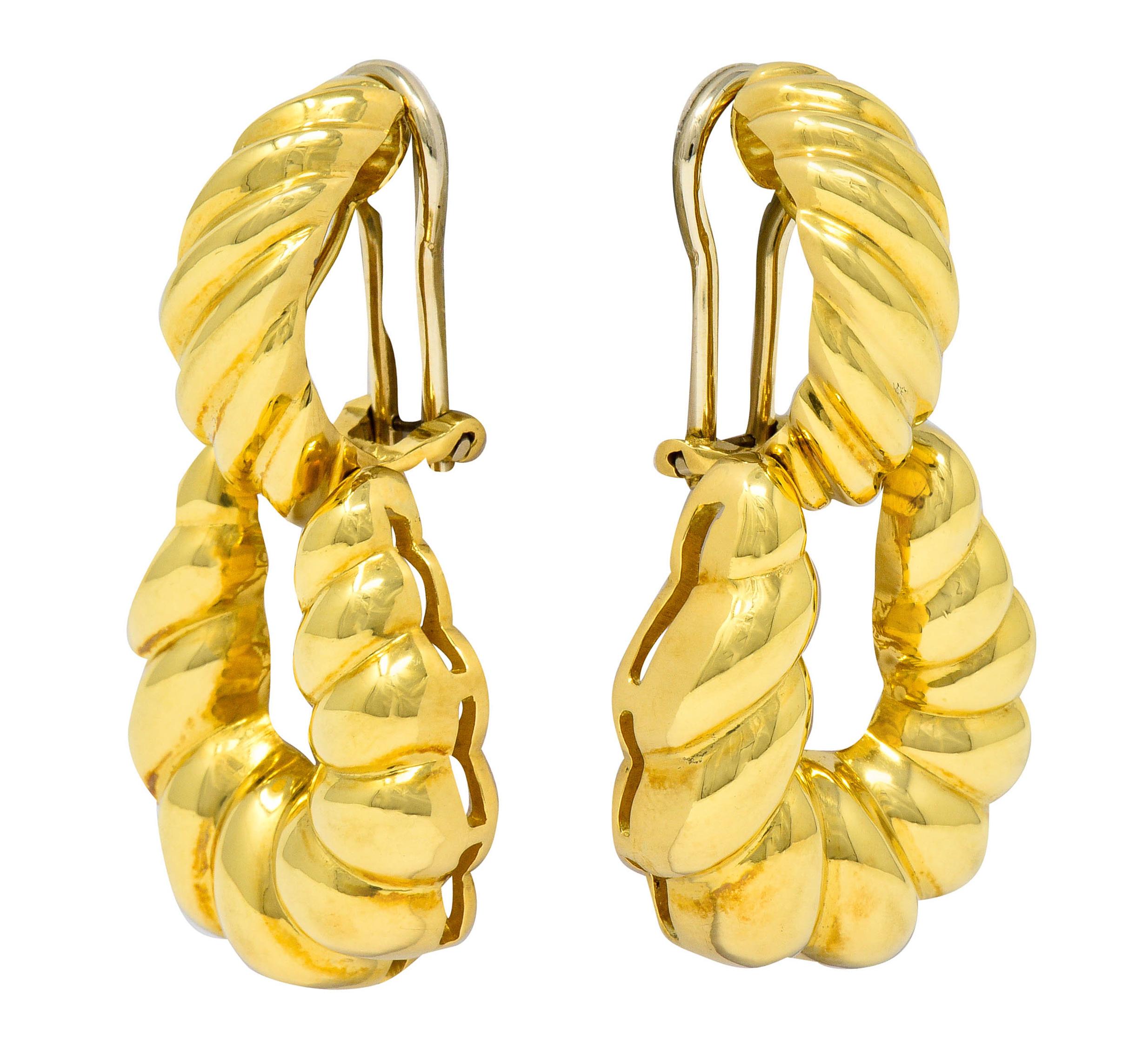 Doorknocker style earrings designed as a half hooped surmount suspending an articulated loop

Both surmount and loop are deeply ribbed and highly polished

Completed by hinged white gold omega backs

Signed T&Co. Italy

With Italian assay marks for