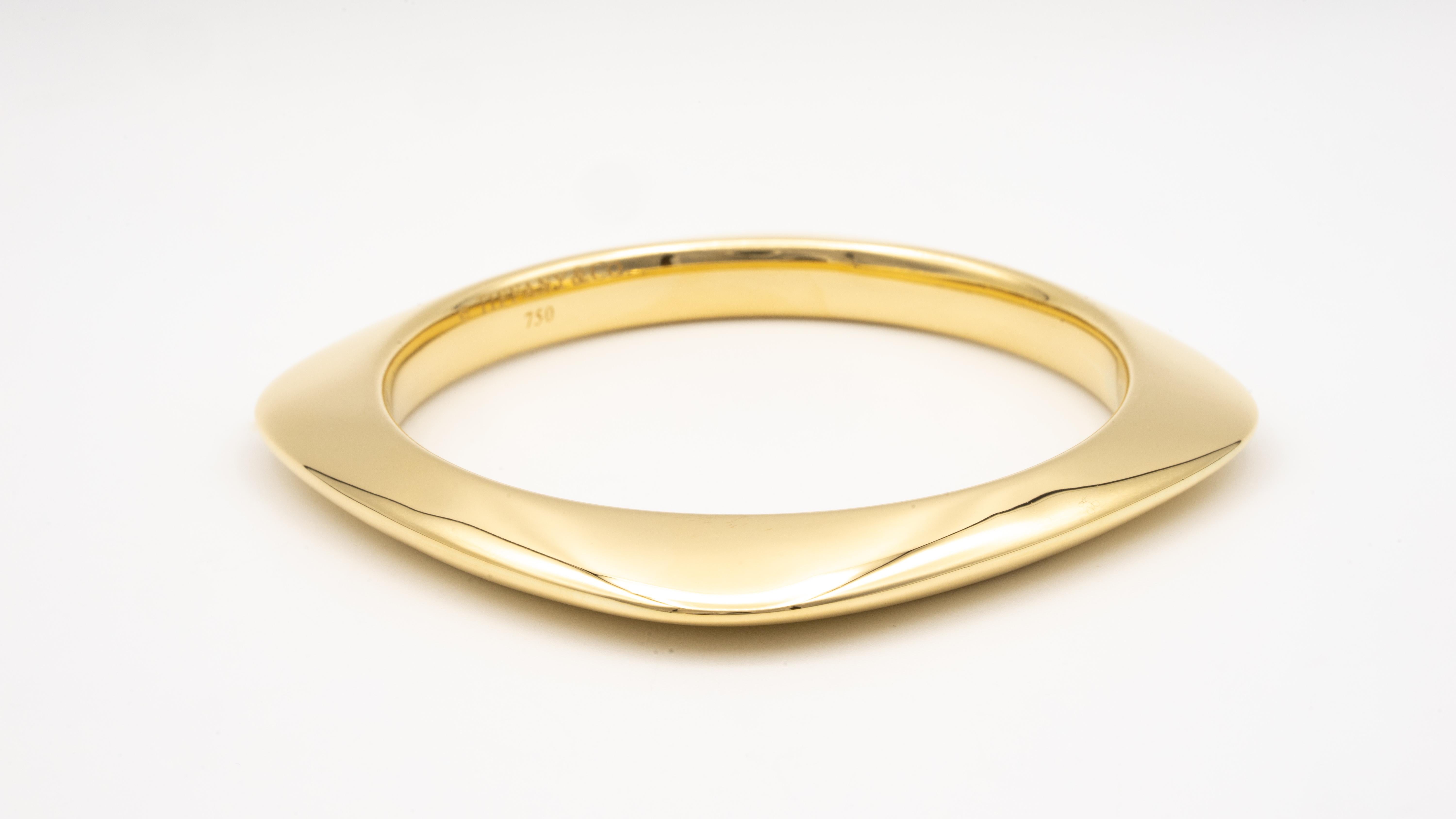 Tiffany & Co. Square cushion shaped bangle finely crafted in high polished 18 Karat yellow gold with round shape on the inside.
Measurement: inner circumference: 8 inches x 0.45