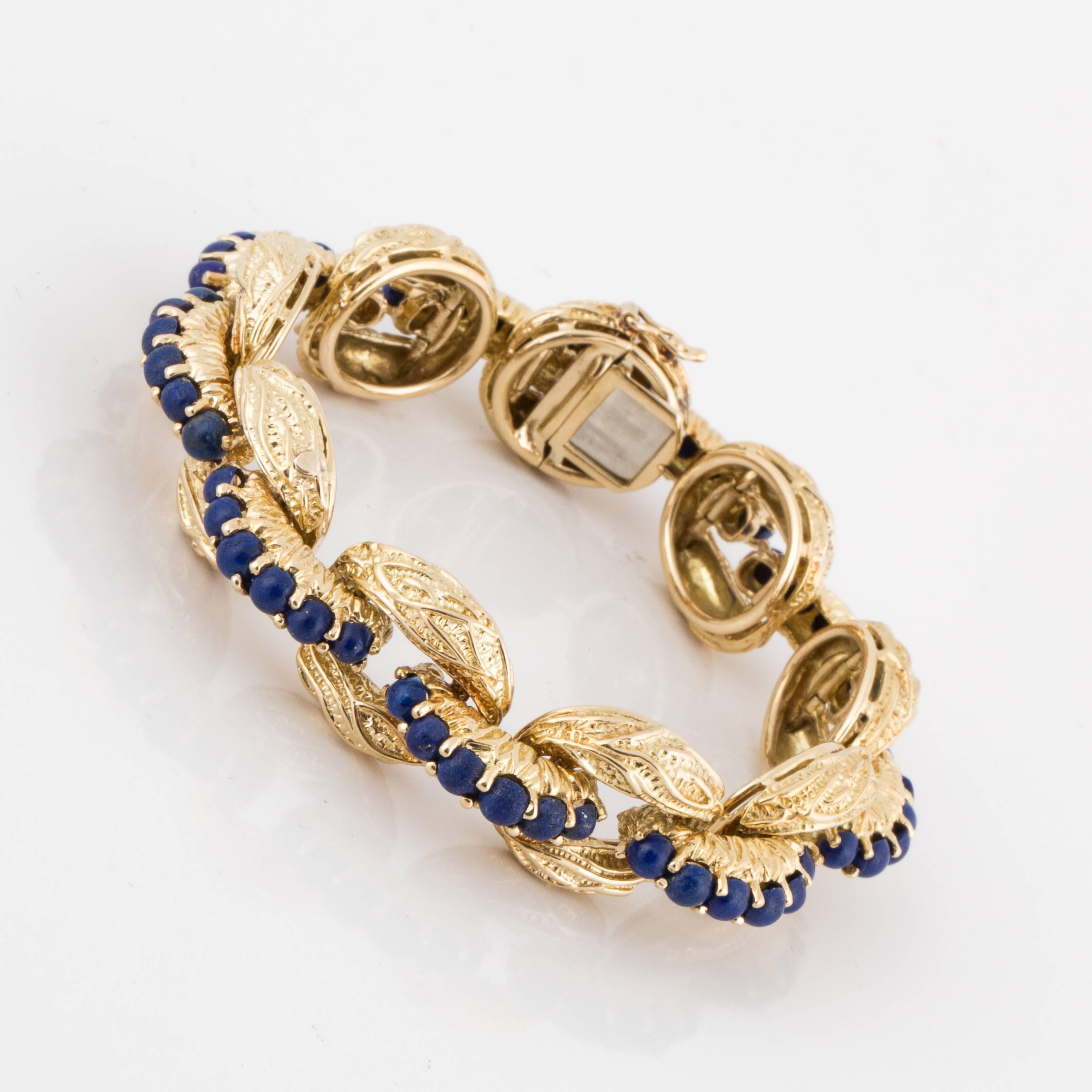 Tiffany & Co. textured oval link bracelet in 18K yellow gold with lapis beads down the center adjoining the links.  There are a total of 47 lapis beads.  The bracelet measures 7 3/8 inches long and it is 5/8 inches wide.  