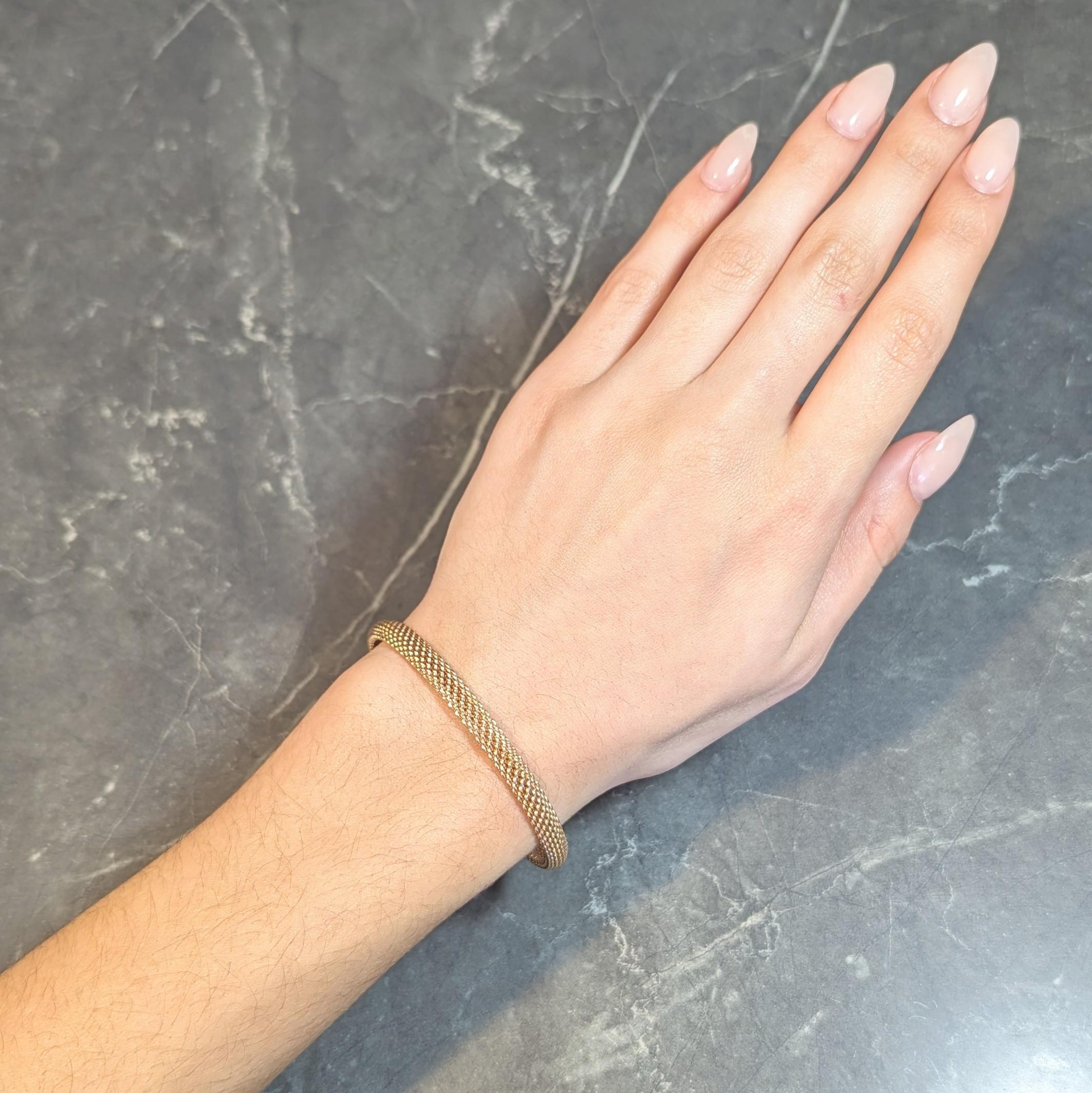 Designed as a curved bangle comprised of woven rose gold
Meshed with limited flexibility
Stamped for 18 karat gold
With maker's mark for Tiffany & Co.
Circa: 2000s; via the Somerset collection
Width: 1/4 inch
Bracelet size: 7 1/2 inch circumference