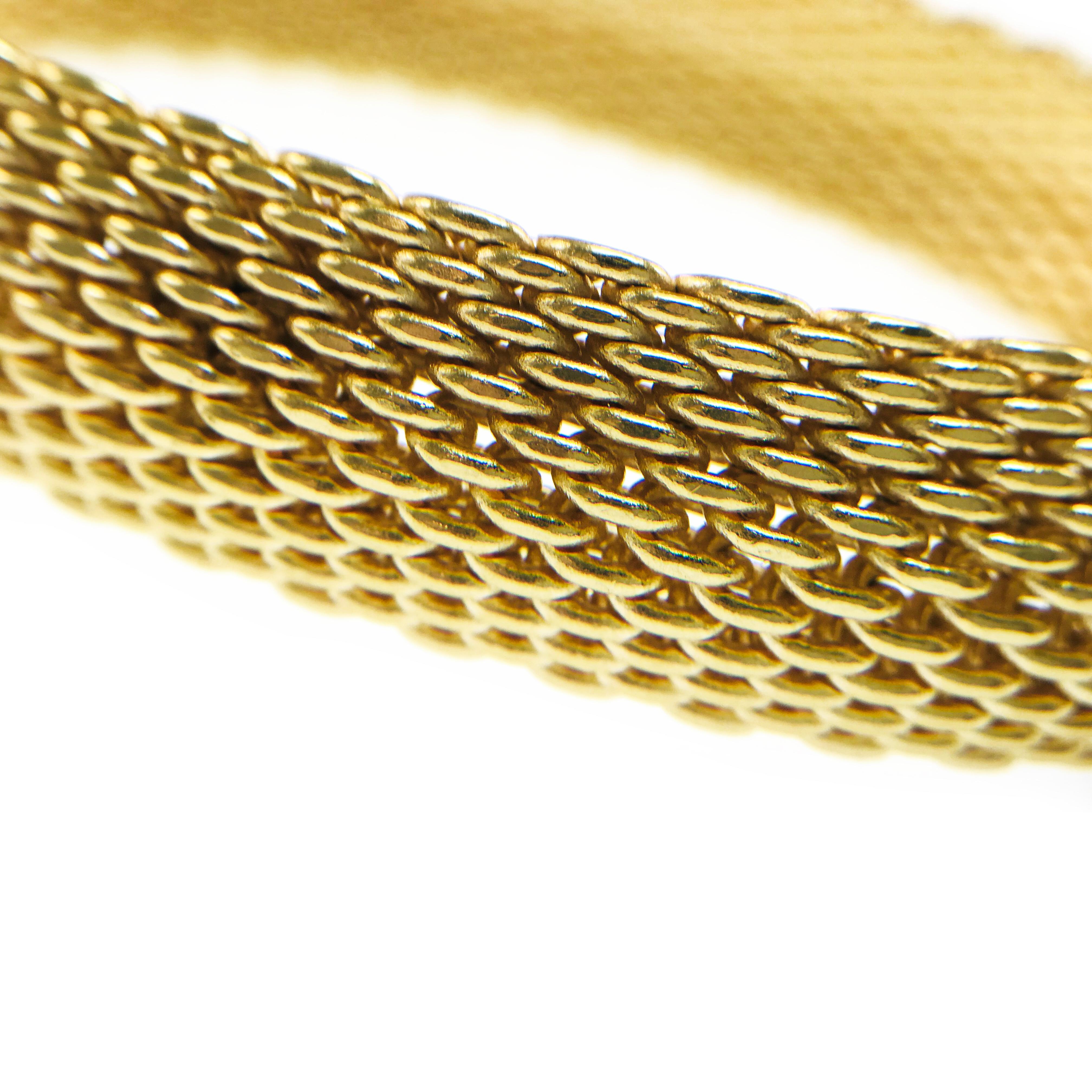 Tiffany & Co. 18 Karat Somerset Yellow Gold Mesh Bangle Bracelet. A magnificent heavyweight mesh bracelet that effortlessly slips over the wrist. The continuous bold and intricate mesh design is a statement of beauty and refinement. Stamped on the