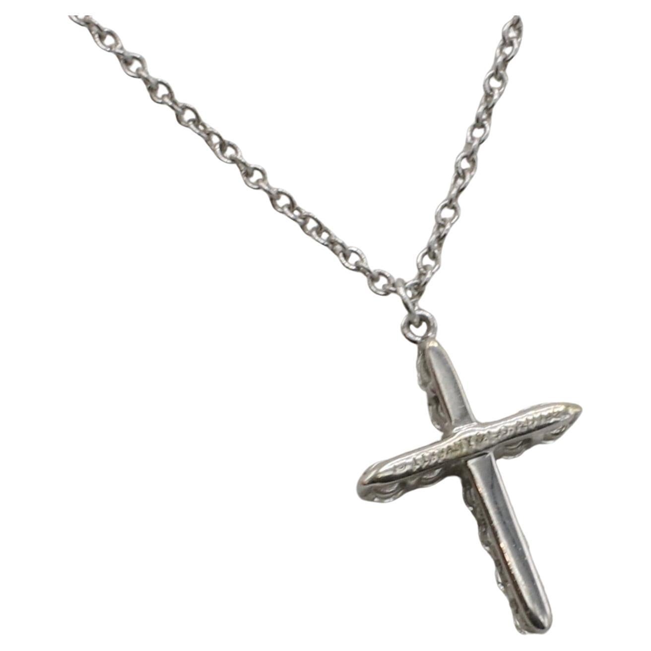 Tiffany & Co. 18 Karat White Gold Cross Natural Diamond Pendant Necklace 
Metal: 18k white gold
Weight: 2.48 grams
Cross: 13.7 x 10mm
Diamonds: Approx. 0.20 CTW E-F VVS round natural diamonds
Length: 22 inches
Signed: ©Tiffany & Co. Au750
TDD
