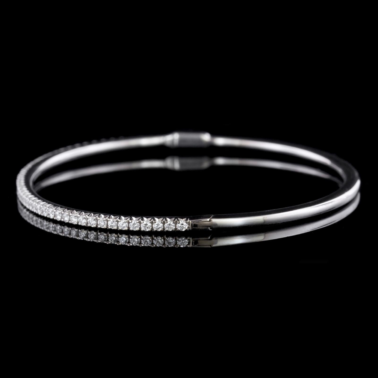 Tiffany & Co. 18K White Gold Metro Diamond Bangle. The bracelet is a hinged
bangle set with 17 full cut diamonds weighing .73cttw., G color, VS clarity, interior
circumference 7