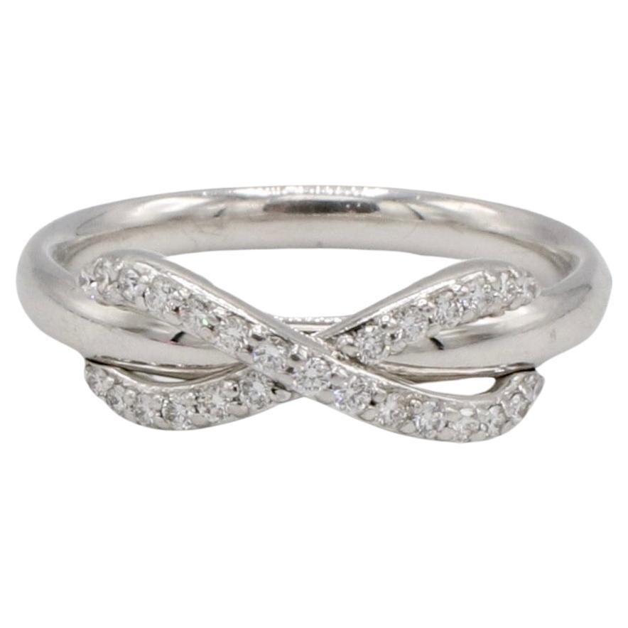 Tiffany & Co. 18 Karat White Gold Natural Diamond Infinity Band Ring 
Metal: 18k white gold
Weight: 3.87 grams
Diamonds: Approx. .15 CTW natural round diamonds G VS
Size: 5 (US)
Infinity design: 14.5 x 5.5mm
Signed: ©T&Co. AU 750 ITALY