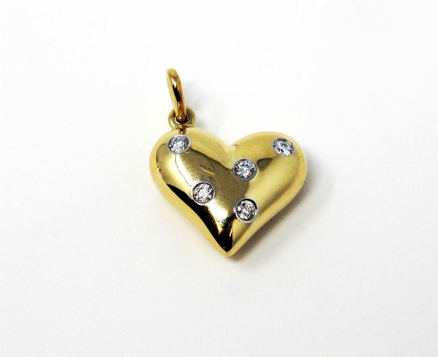 Absolutely gorgeous Etoile diamond heart pendant from Tiffany & Co. Dazzling round diamonds are scattered throughout this solid gold heart, offering sparkle from all angles. The feminine, romantic style radiates on the neck, while the classic shape