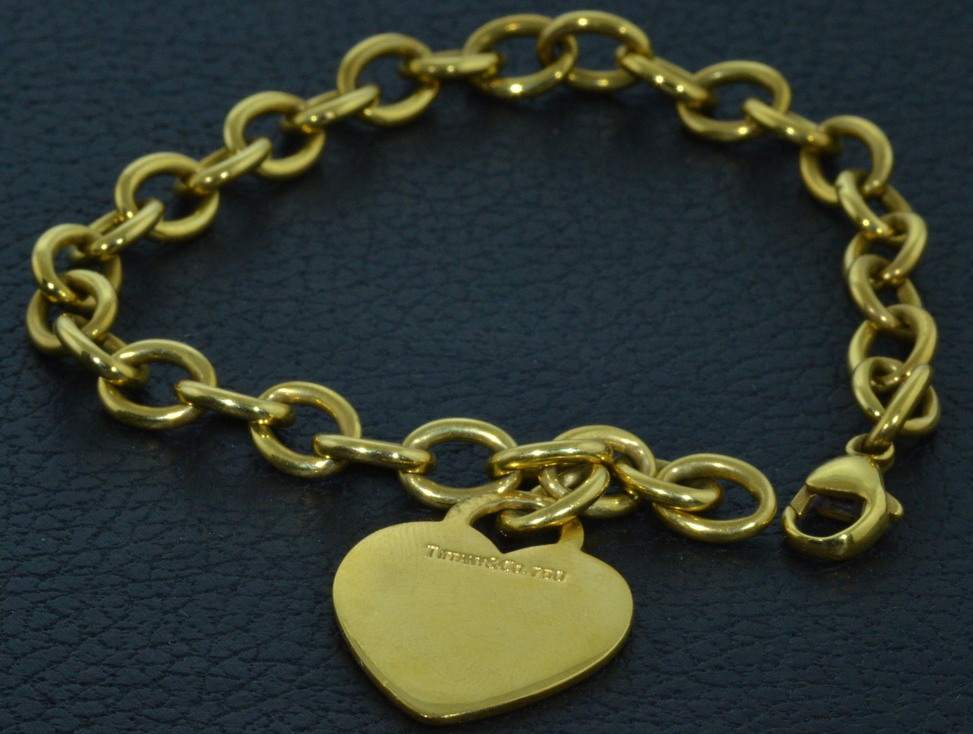 Classic, timeless authentic Tiffany & Co. solid 18 karat yellow gold oval link chain bracelet with a heart shaped charm. Heart has a high polish, blank front and is hallmarked on the back, 