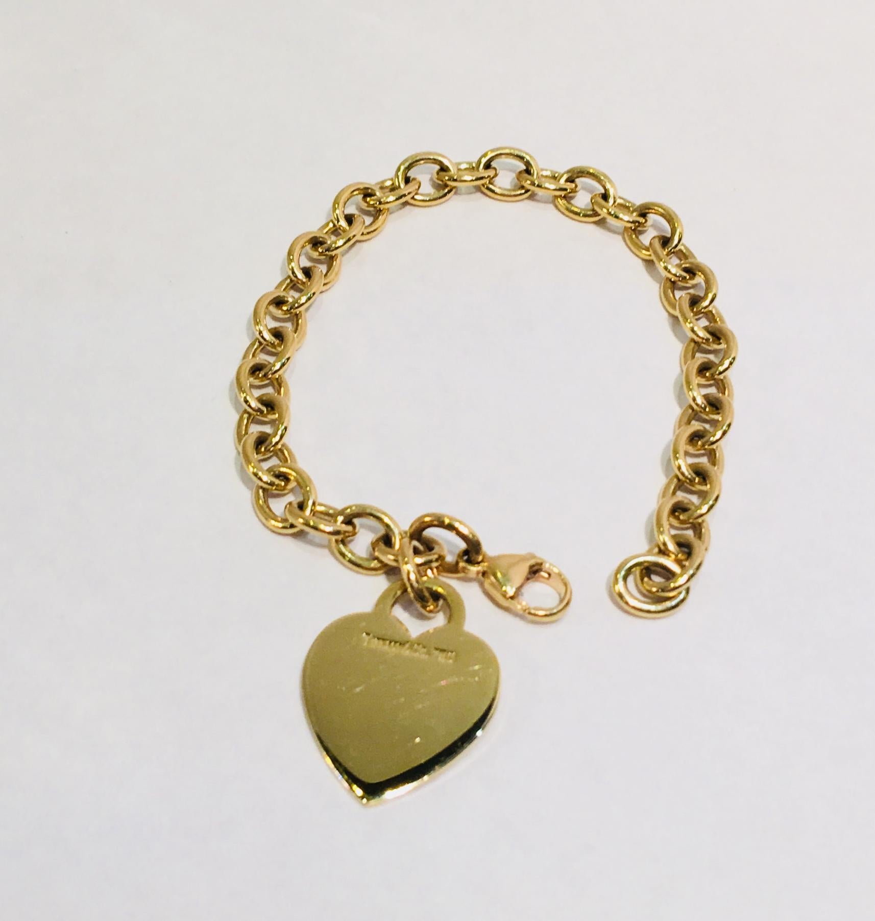 Classic, timeless authentic Tiffany & Co. solid 18 karat yellow gold oval link chain bracelet with a heart shaped charm.  A prefect gift for Valentine's Day!  Heart has a high polish, blank front and is hallmarked on the back, 