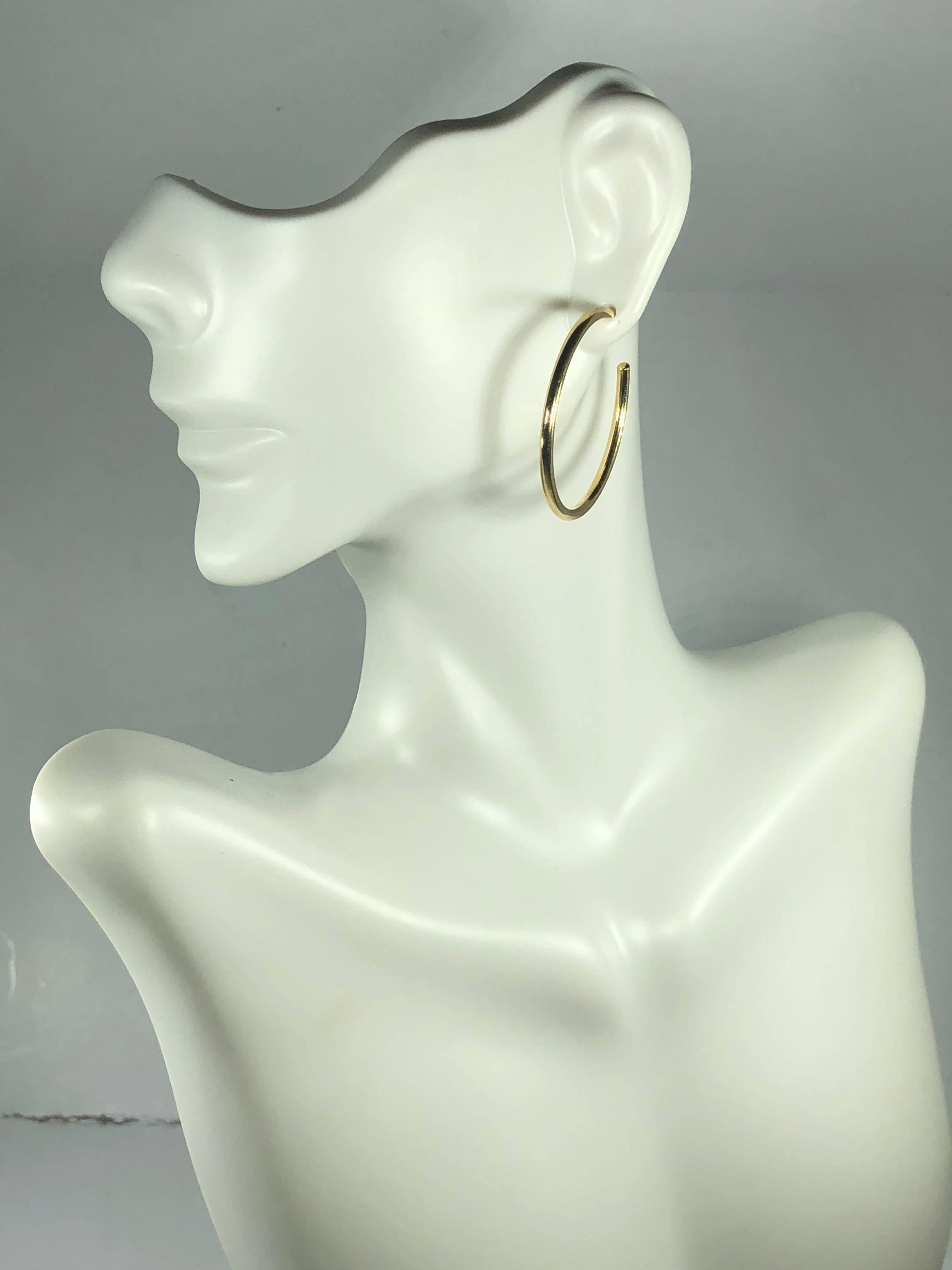 Tiffany &Co 18 karat yellow gold classic hoop earrings. Signed Tiffany & Co classic hoop earrings created in 18 karat yellow gold. These earrings weigh 4.3 grams collectively. Original T& Co backings also in 750 18 karat yellow gold. Each individual