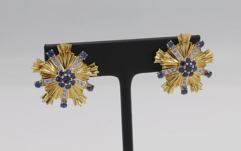 Tiffany & Co. 18 Karat Yellow Gold Diamond & Blue Sapphire Starburst Earrings 
Metal: 18k yellow gold
Weight: 17.98 grams
Diamonds: .60 CTW G VS round diamonds
Diameter: 26mm 
Backs: Lever backs with posts
