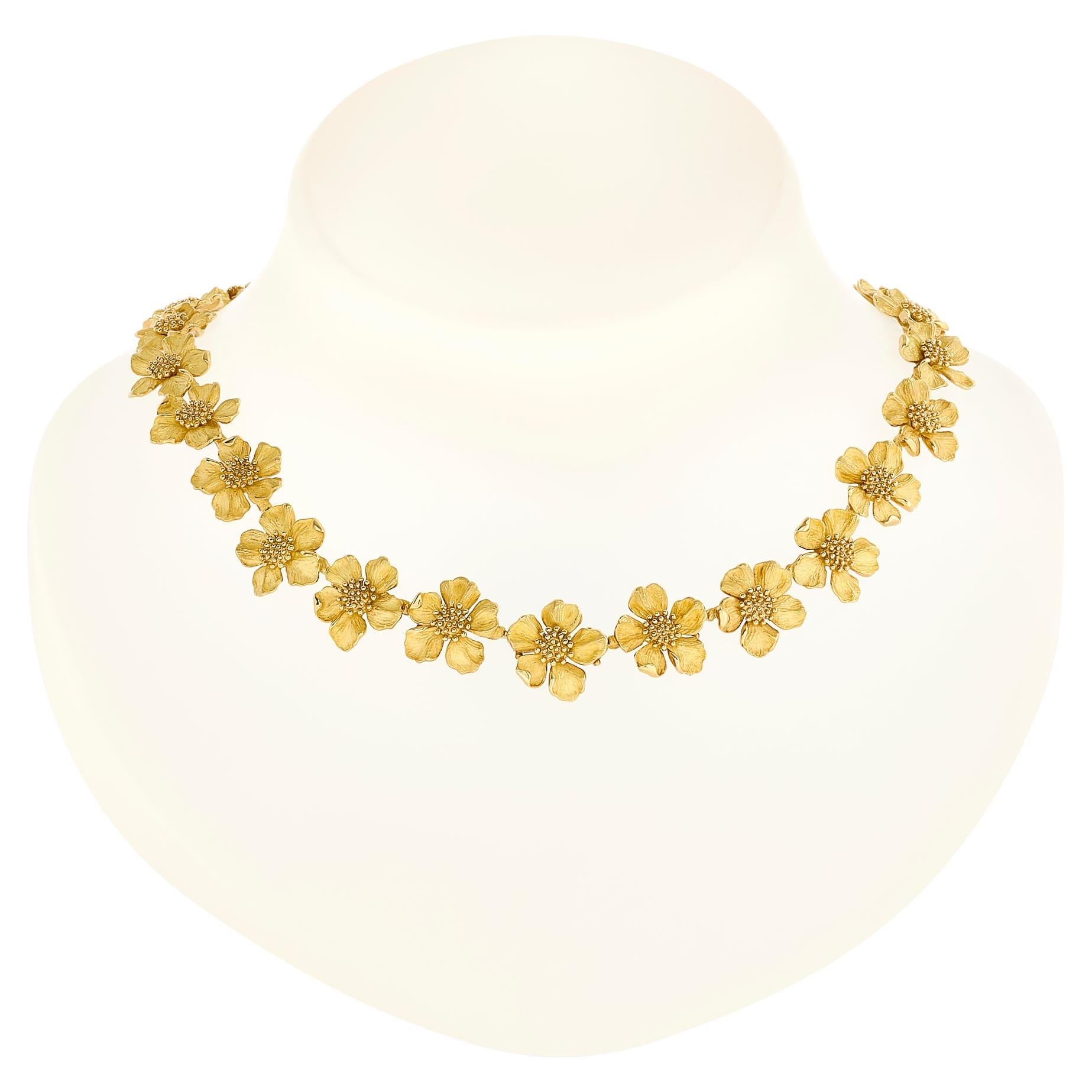 The classic Tiffany & Co. Dogwood flower necklace in all 18 karat yellow gold is a stunning piece of jewelry that exudes elegance and timeless beauty. 

Signed 