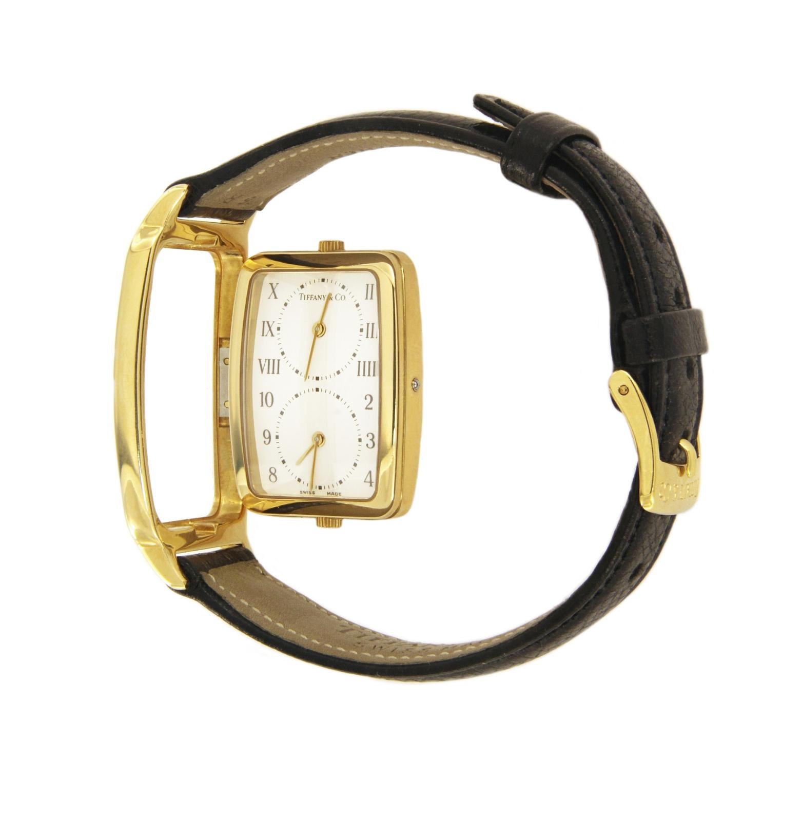 TIFFANY & CO. 18 KARAT YELLOW GOLD DUAL TIME ZONE WATCH M203

-Case size: 26.5mm
-Case thickness: 6.5mm
-Case: 18k Yellow Gold
-Movement: Swiss Quartz
-Dial: White with Roman Numerals and Arabic Numbers
-Strap: Black Leather