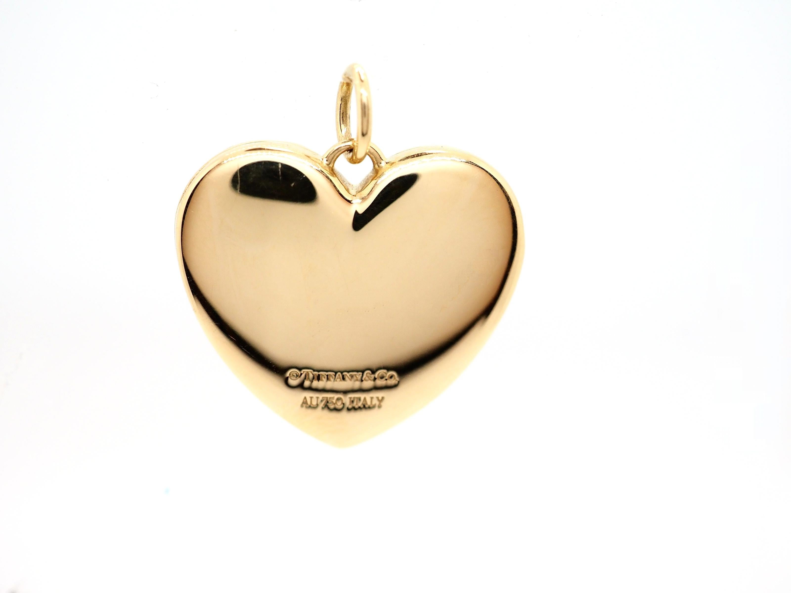 A rare authentic pendant made of 18 Karat yellow gold  (usually the is designed as a puffed high polished yellow gold heart. Opens on a hinge to reveal two heart shaped box where you can place the photos or something special and private for you.