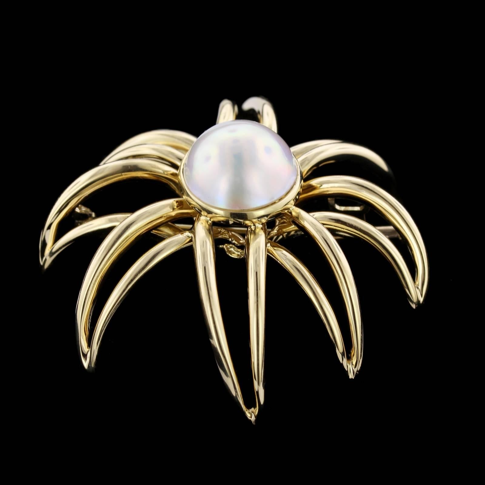 Tiffany & Co. 18K Yellow Gold Mabe Pearl Fireworks Brooch. The brooch is set with a mabe pearl measuring 14.50mm., diameter 1 15/16