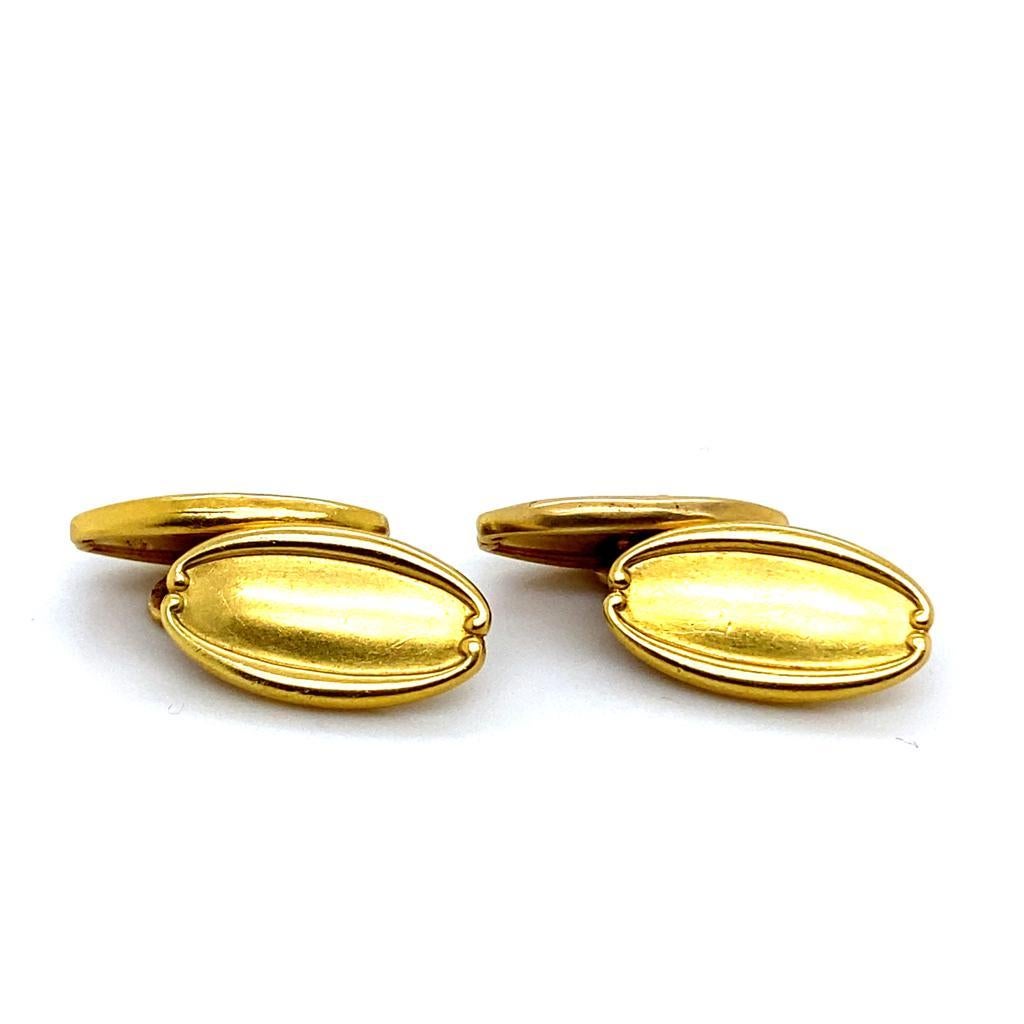 A pair of Tiffany & Co. 18 karat yellow gold oval cufflinks, circa 1960.

These smart vintage cufflinks are designed as a pair of matching oval yellow gold discs with scrolled detail to each.

The unusual figure of eight gold fittings between the