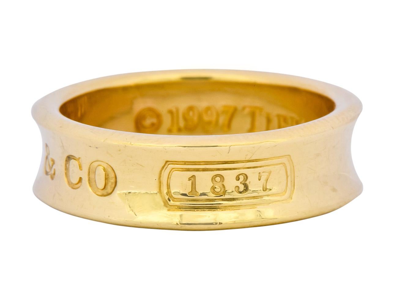 High polished gold band with recessed central groove

Deeply engraved to front 750, T & Co., and 1837

From Tiffany & Co.'s celebratory Tiffany 1837 Collection

Inner shank fully signed Tiffany & Co. 1997

Stamped 750 for 18 karat gold

Ring Size: 6