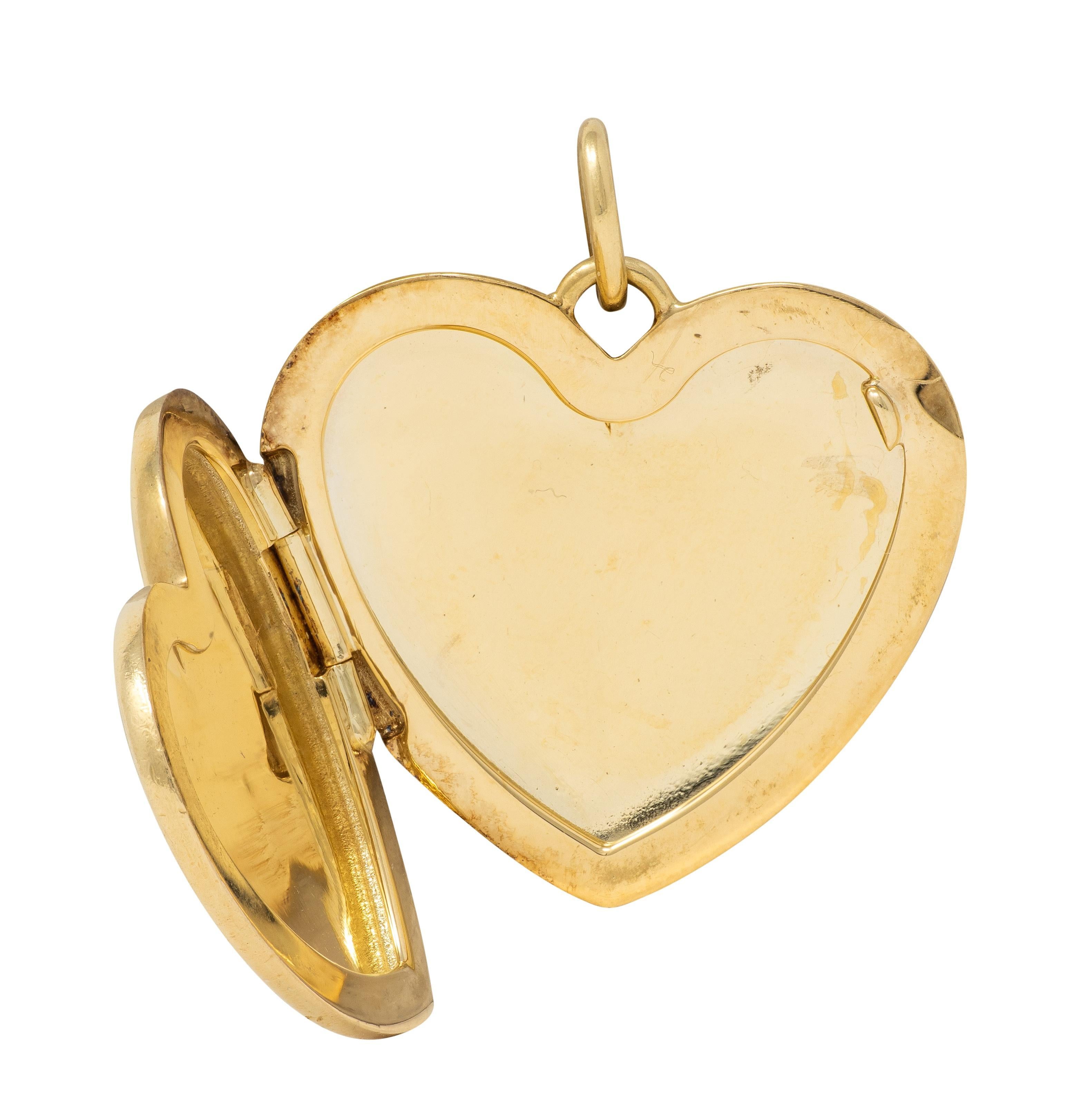 Designed as a heart-shaped locket pendant suspending from a jump ring bale
Slightly domed with puffy appearance and high polish finish
Opens on a hinge to reveal recessed frames
Edge of locket is indented for easy opening
Stamped for 18 karat