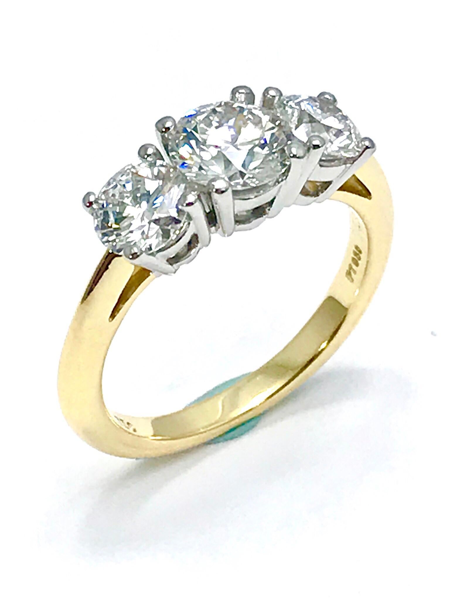 A beautiful classic Tiffany & Co. 1.82 carat total weight three Diamond platinum and 18 karat yellow gold ring.  The three round brilliant Diamonds are set in four prong basket settings, made in platinum, with an 18 karat yellow shank.  All three