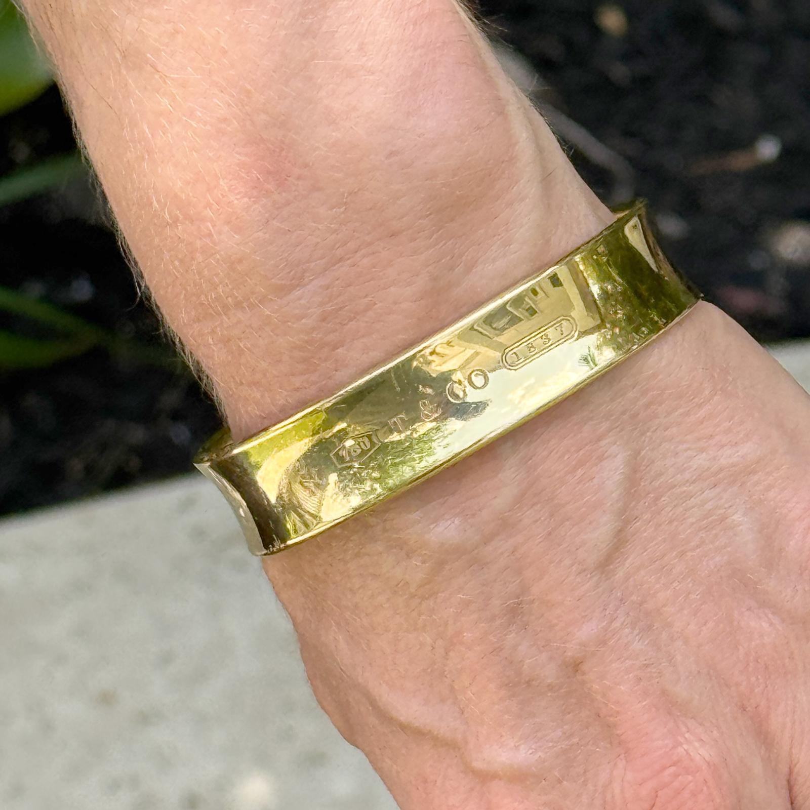 This striking Tiffany & Co. 1837 bangle bracelet is crafted from solid 18 karat yellow gold and features a bold 15mm width with a sleek squared, high-polish finish. The iconic T&Co. 1837 hallmark is elegantly engraved, celebrating the brand’s