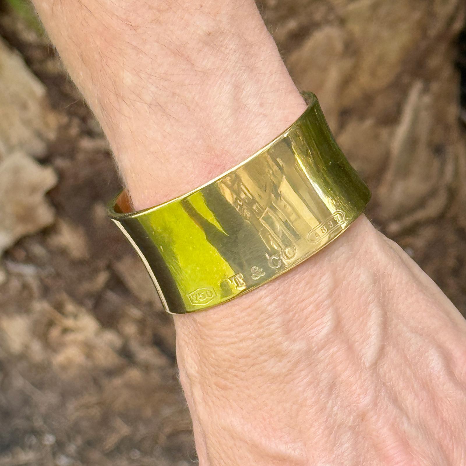 This bold and elegant Tiffany & Co. cuff bracelet, circa 2001, is expertly crafted in rich 18 karat yellow gold. Measuring approximately 1.25 inches in width, it features a sleek, sculptural silhouette with a polished finish. The piece has an
