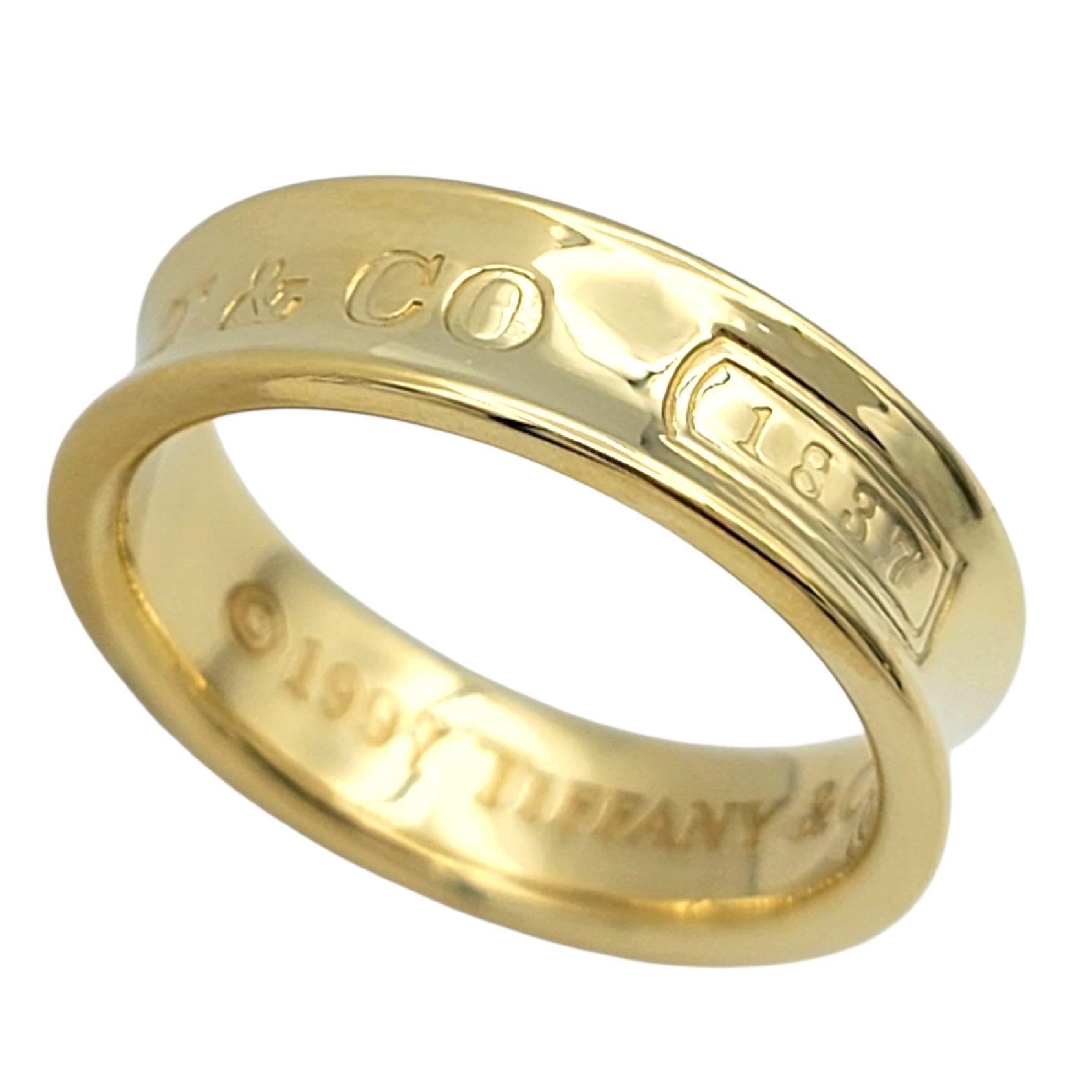 Tamaño del anillo: 8

Este anillo de banda Tiffany & Co. de la colección 1837 es un clásico atemporal en rico oro amarillo de 18 quilates. El diseño de anchura media presenta una silueta suavemente cóncava con el icónico sello 