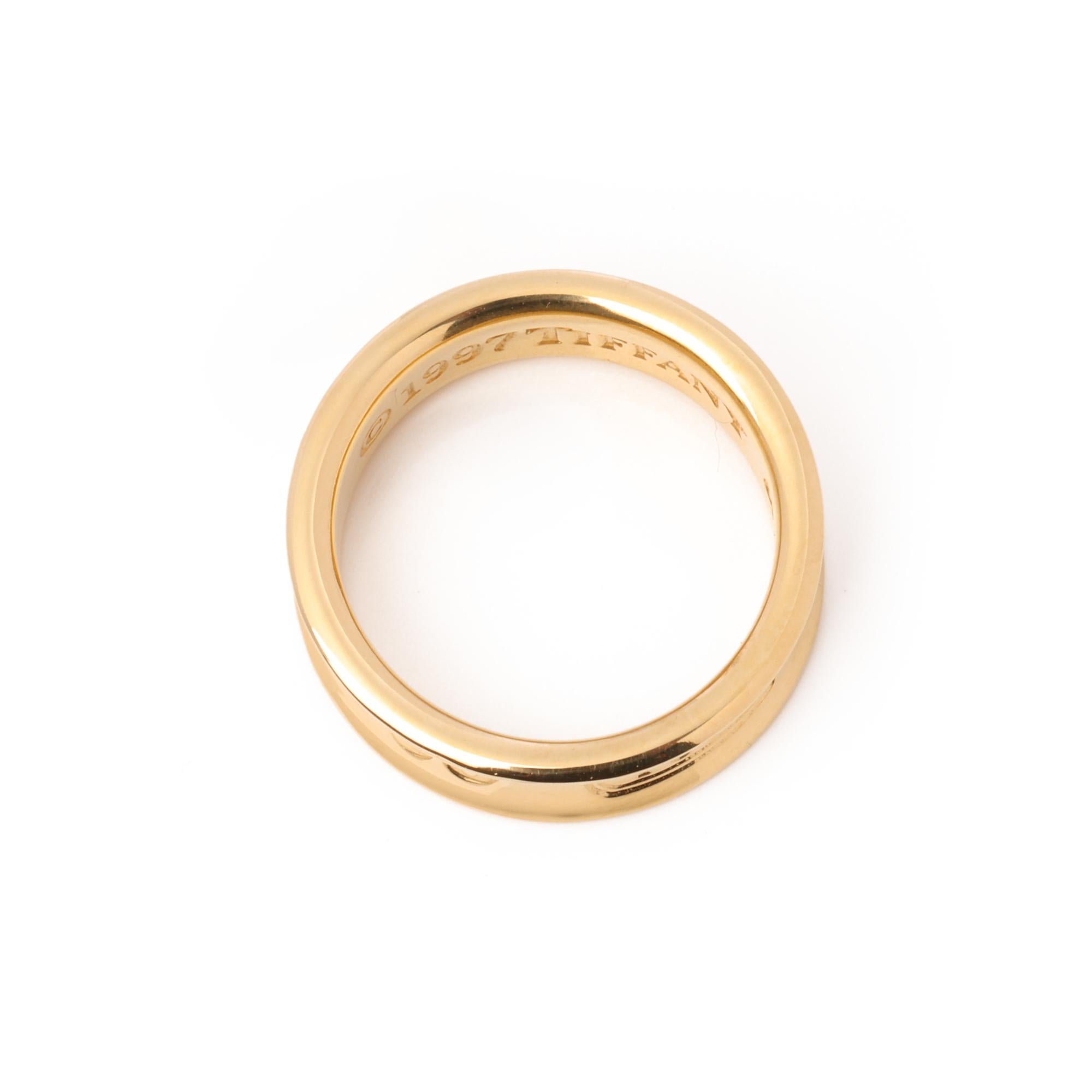 This ring by Tiffany & Co is from their 1837 collection and features a contoured design in 18ct yellow gold. 