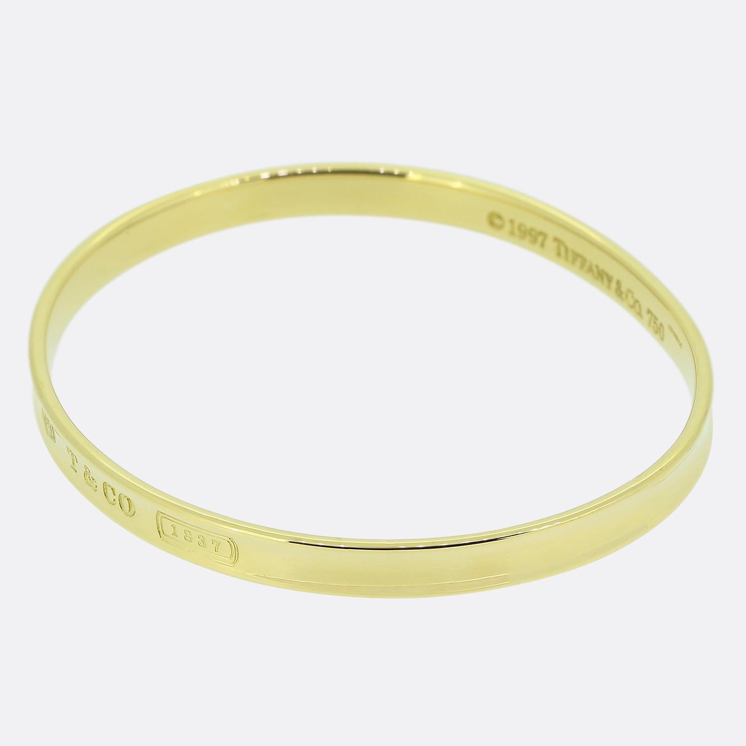 Here we have an 18ct yellow gold bangle from the world renowned jewellery designer Tiffany & Co. This bangle has been crafted from a warm 18ct yellow gold and offers a slip-on design suitable for everyday wear.  At the front of the face we find