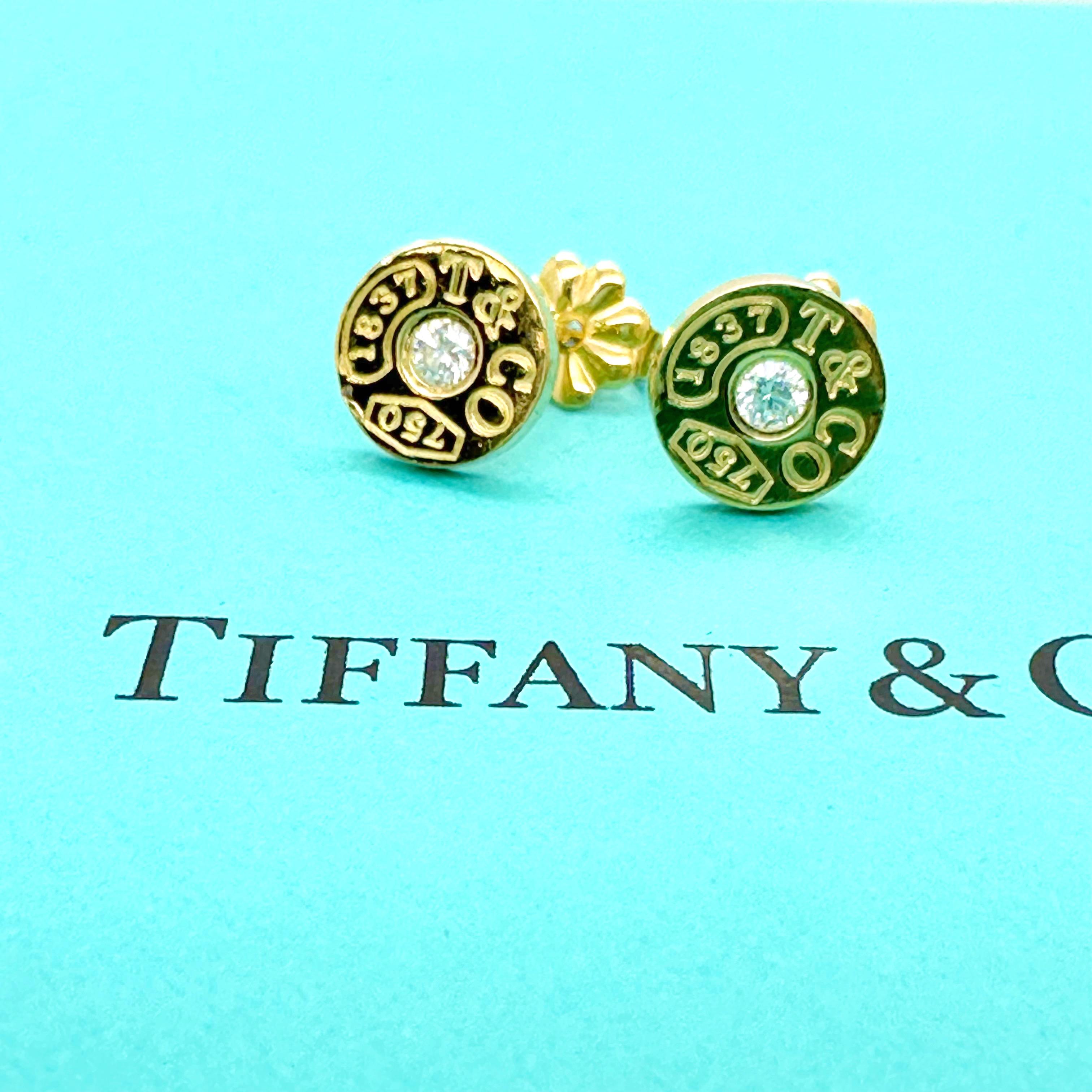 Tiffany & Co. 1837 Circle Earrings
Style:  Bezel Set Studs
Ref. number:  #60011276
Metal:  18kt Yellow Gold
Size / Measurements:  Small ~ 8 mm Diameter
Main Diamond:  Round Brilliant Diamonds
Hallmark:  1837 T&Co750 on front of earrings - T&Co Au750