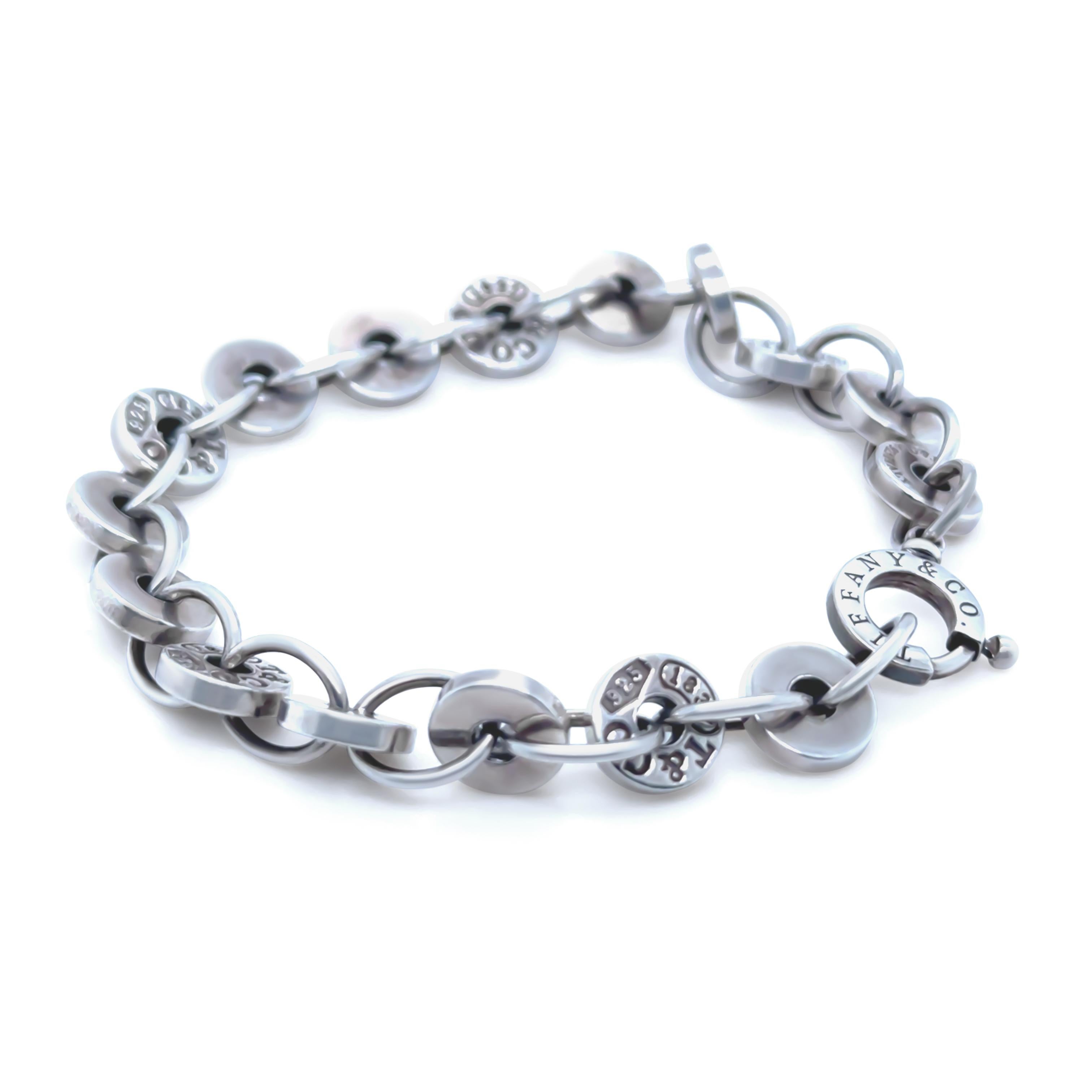 This refined Tiffany & Co. 1837 Circle bracelet is crafted in sterling silver, featuring interlocking circle links and an engraved tag from Tiffany’s signature 1837 collection. A modern classic, it embodies understated luxury and timeless