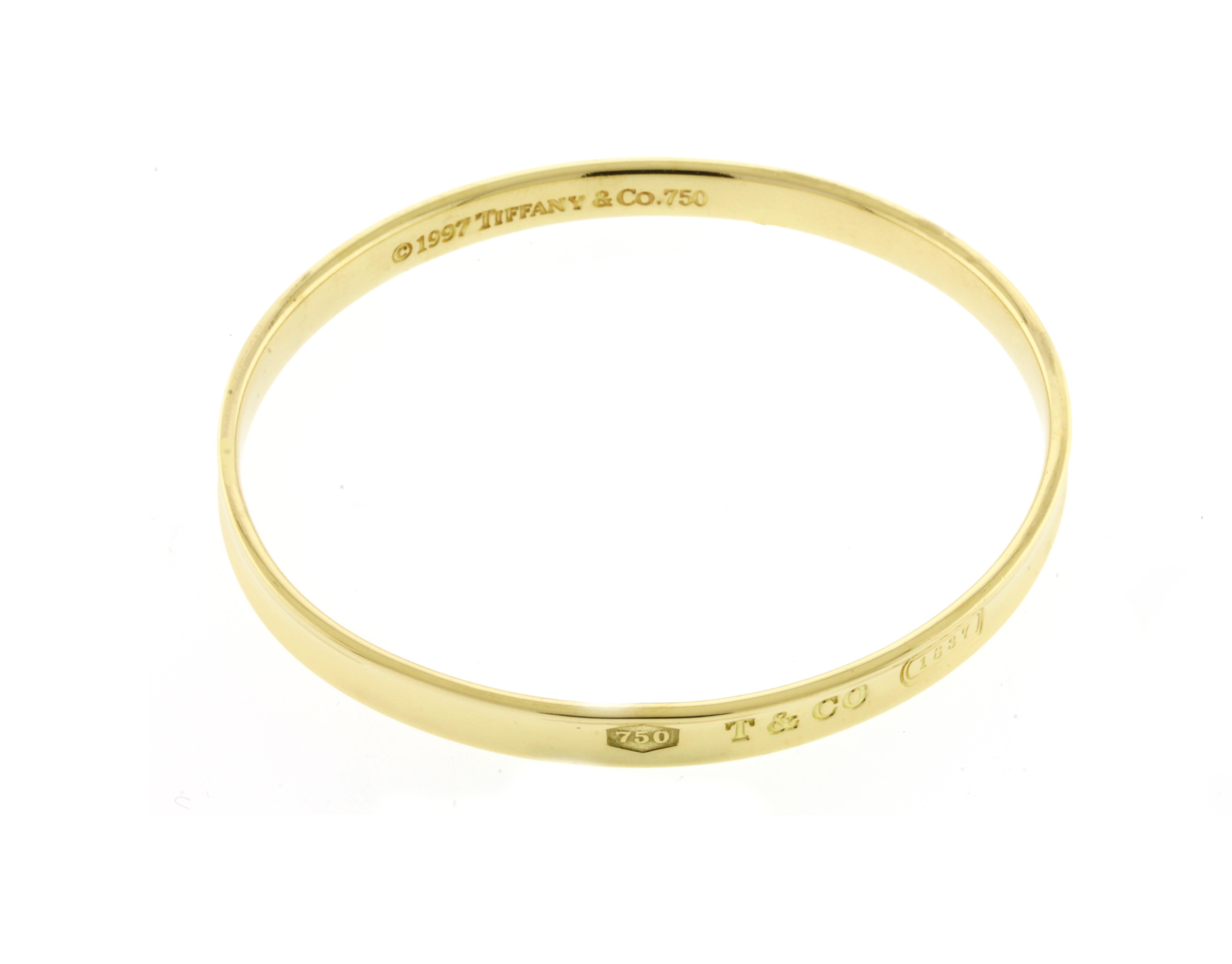 From the 1837 collection by Tiffany & Co., this bangle has 750, T & CO and 1837 on the outside of the bracelet.  
• Designer: Tiffany & Co.
• Metal: 18 karat gold
• Circa: 1997
• Weight: 29.8 grams
• Packaging:  Tiffany Box
• Condition: Good
