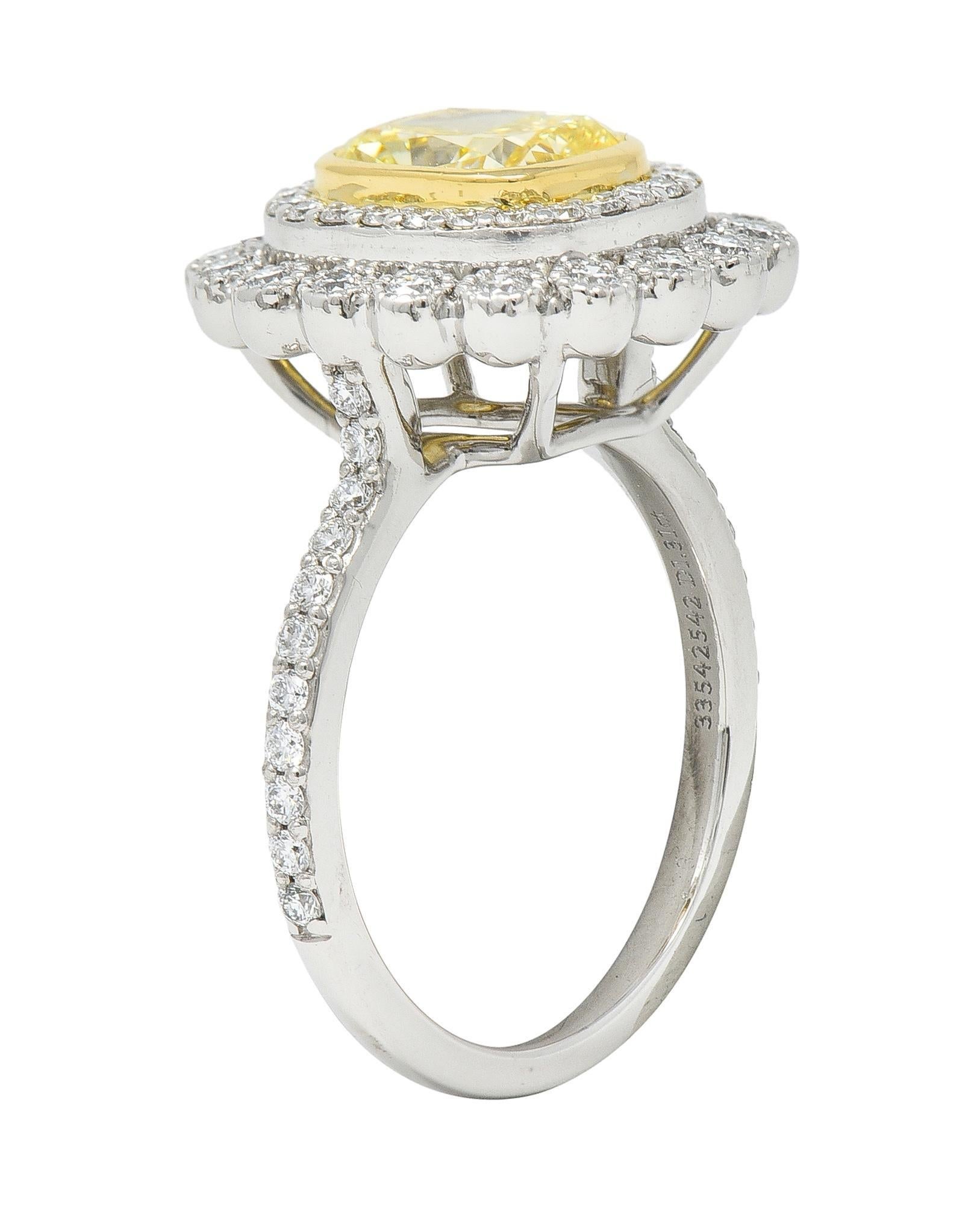 Centering an elongated cushion cut diamond weighing 1.31 carats - fancy intense yellow in color with VS2 clarity
Set in a yellow gold bezel with a tiered halo surround of round brilliant cut diamonds
Bead and bezel set in basket with additional