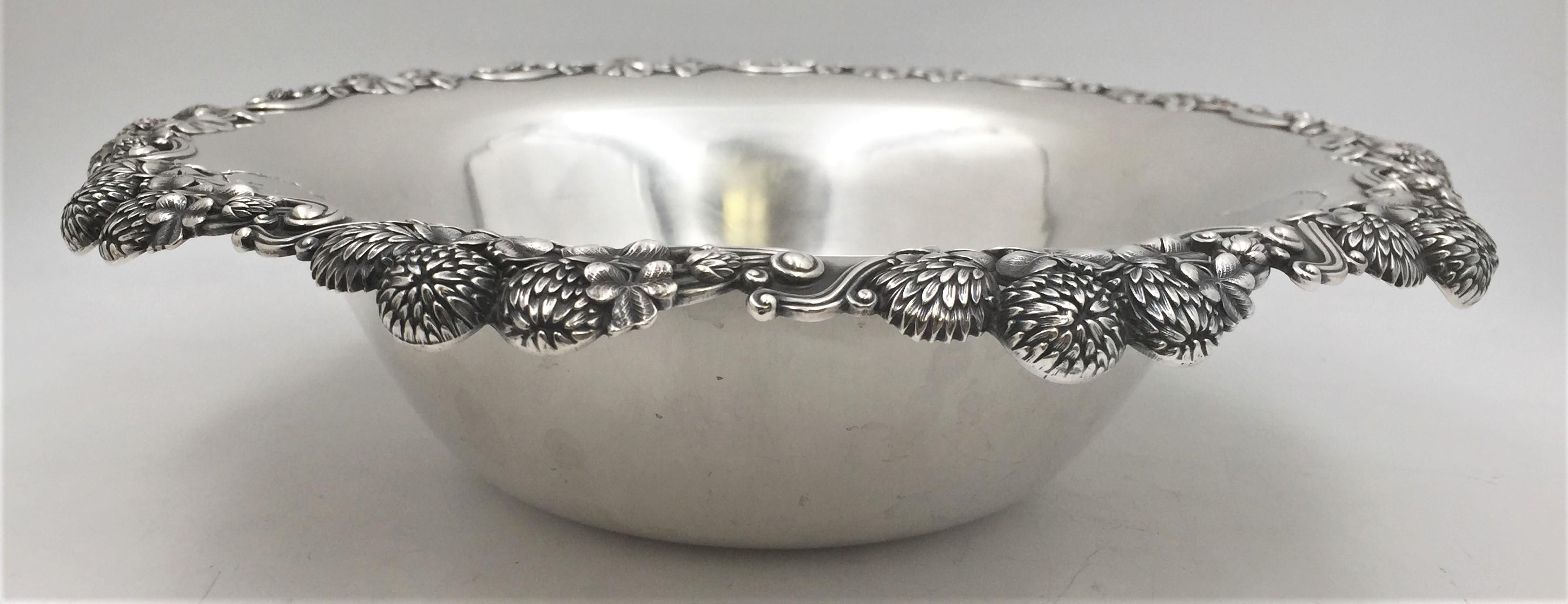Tiffany & Co. sterling silver berry bowl in Art Nouveau style and in Clover pattern in pattern 13780 from 1898 with exquisite raised motifs of flowers, leaves, and twirls around the rim. It measures 14 1/4'' in diameter by 3 2/3'' in height, weighs