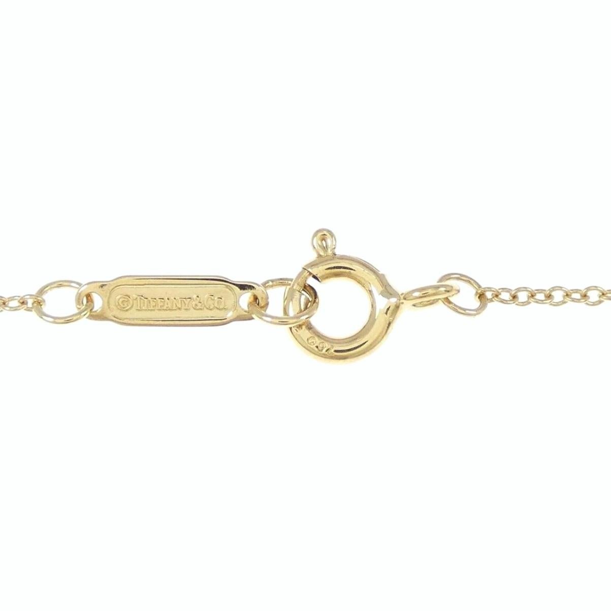 TIFFANY & Co. Collier pendentif croix en or 18K avec diamant de 0,42ct en vente 1