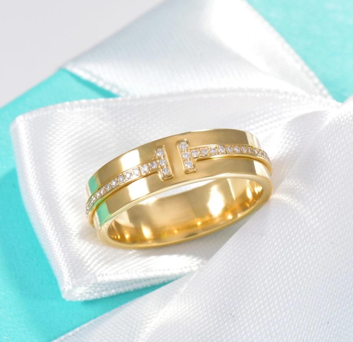 TIFFANY & Co. Anello a T con diamante largo 5,5 mm in oro 18 carati 7

Tiffany T è l'espressione del potenziale infinito dell'amore. Ispirata a un braccialetto d'archivio del 1975, la T è un omaggio al motivo iconico della Maison e allo spirito di