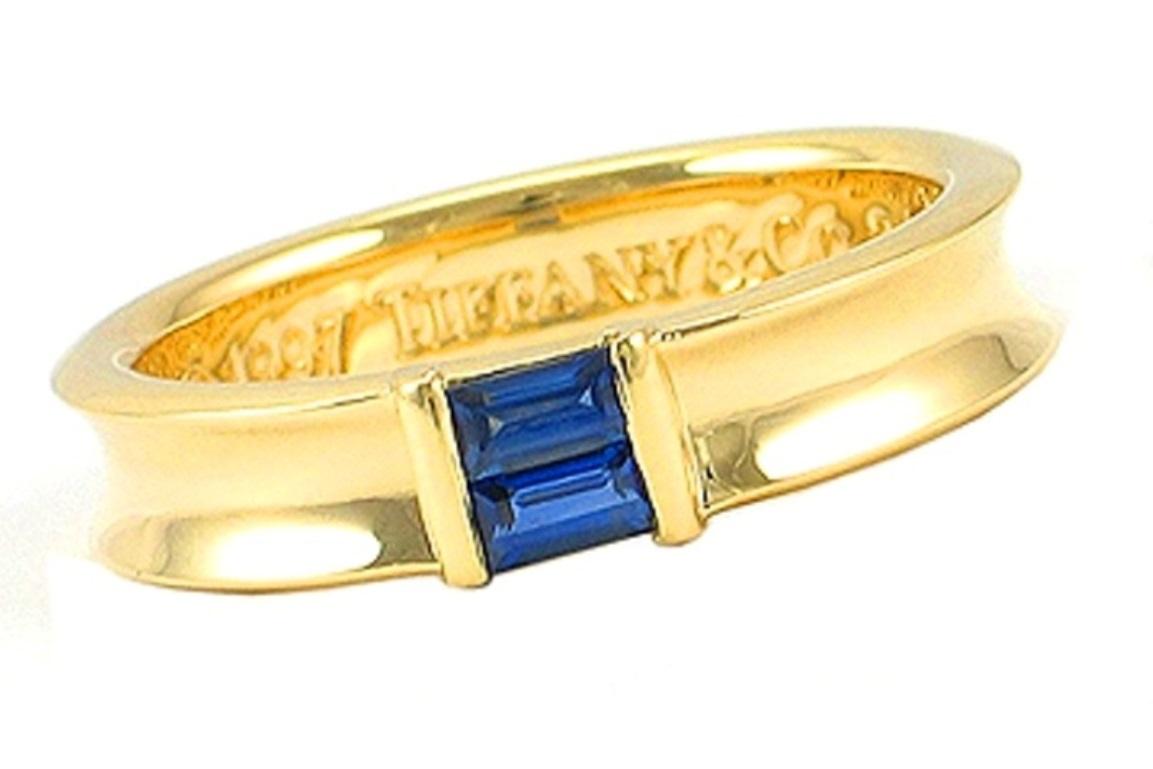 TIFFANY & Co. 18K Gold Blue Sapphire Stacking Ring 5.5 

Metal: 18K yellow gold
Size: 5.5 
Band Width: 4.5mm
Sapphire: two baguette cut blue sapphires, carat total weight .27
Hallmark: ©1997 TIFFANY & Co. 750 

Limited edition, no longer available