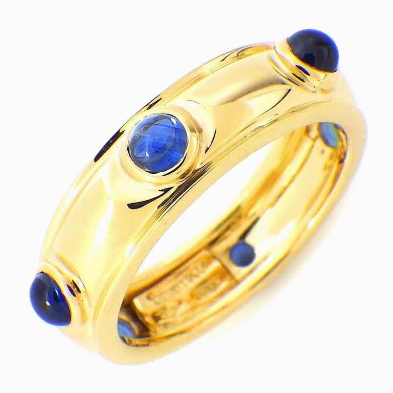 TIFFANY & Co. 18K Gold Cabochon Sapphire Band Ring 5.5

Metal: 18K Yellow Gold 
Size: 5.5 
Band Width: 5.26mm
Weight: 5.40 grams
Sapphire: 6 cabochon sapphires, carat total weight .18 approximately 
Hallmark: TIFFANY&Co. 750 ITALY
Condition: